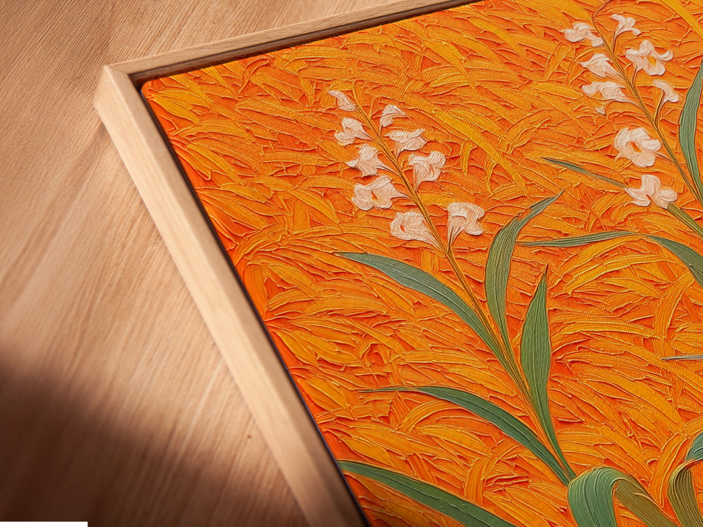 A close-up angled view of a canvas print in a floating frame. The artwork features a floral field with an orange botanical theme. This modern plant artwork is ideal for entryway wall decor. The floating frame adds a contemporary touch. Perfect for living rooms bedrooms and offices.