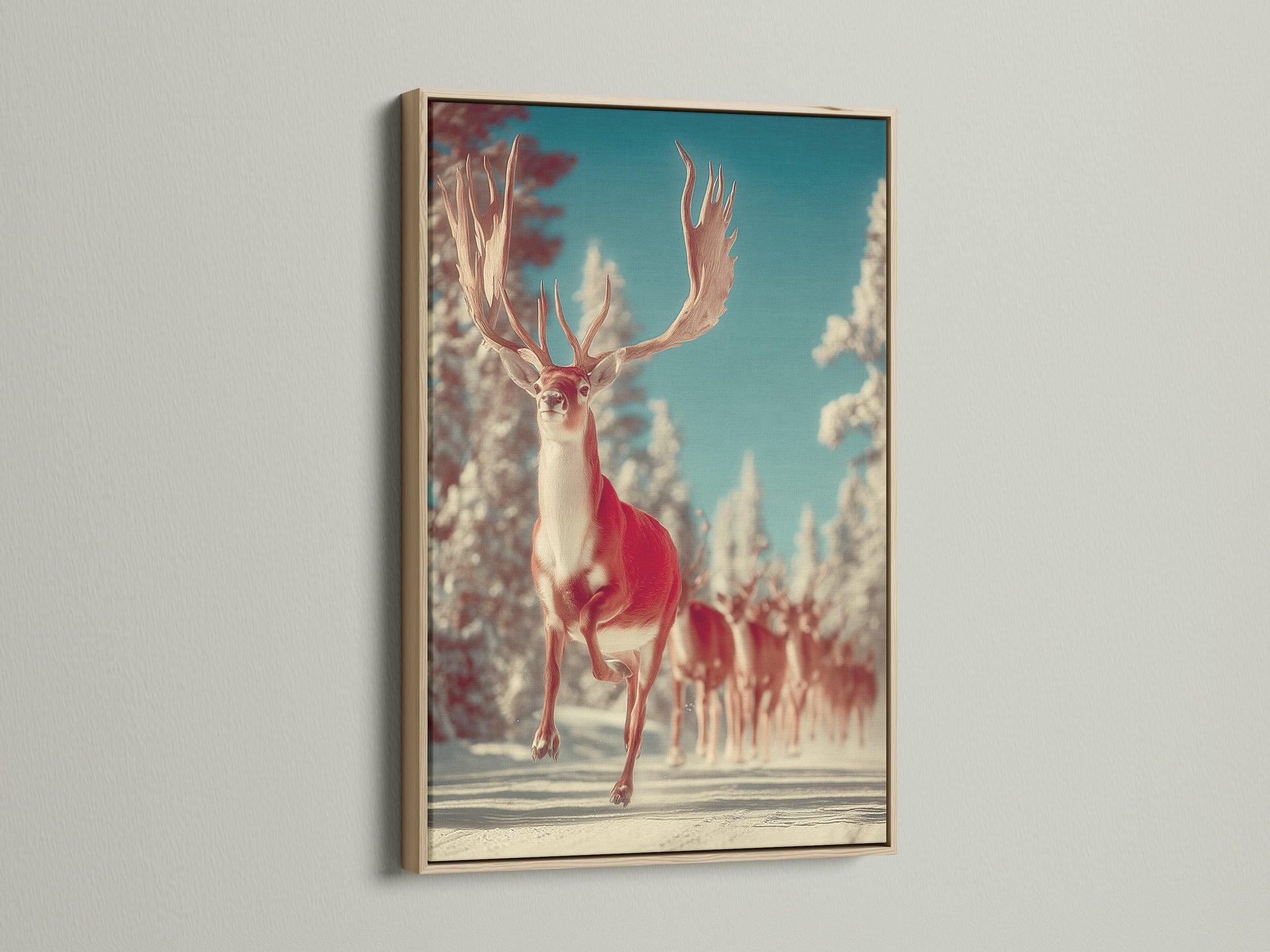 Winter Deer canvas art in an oak frame hangs on a white wall. The snowy animal artwork complements minimalist Scandinavian coastal or farmhouse styles. This animal print is great for living rooms bedrooms cabins studios lodges clinics cafรฉs and boardrooms.