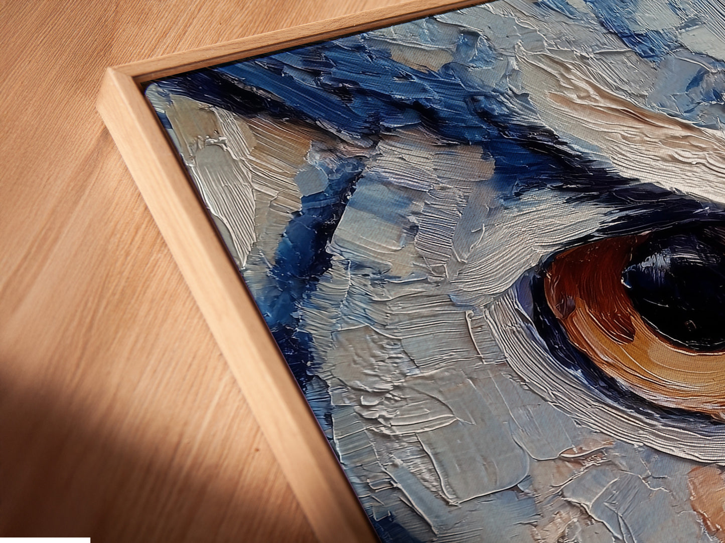 Angled close-up of a canvas print. It's in a floating frame. The artwork features an owl's eye. The floating frame enhances the artwork's depth. It creates a sophisticated display. The image captures the texture and detail of the print.
