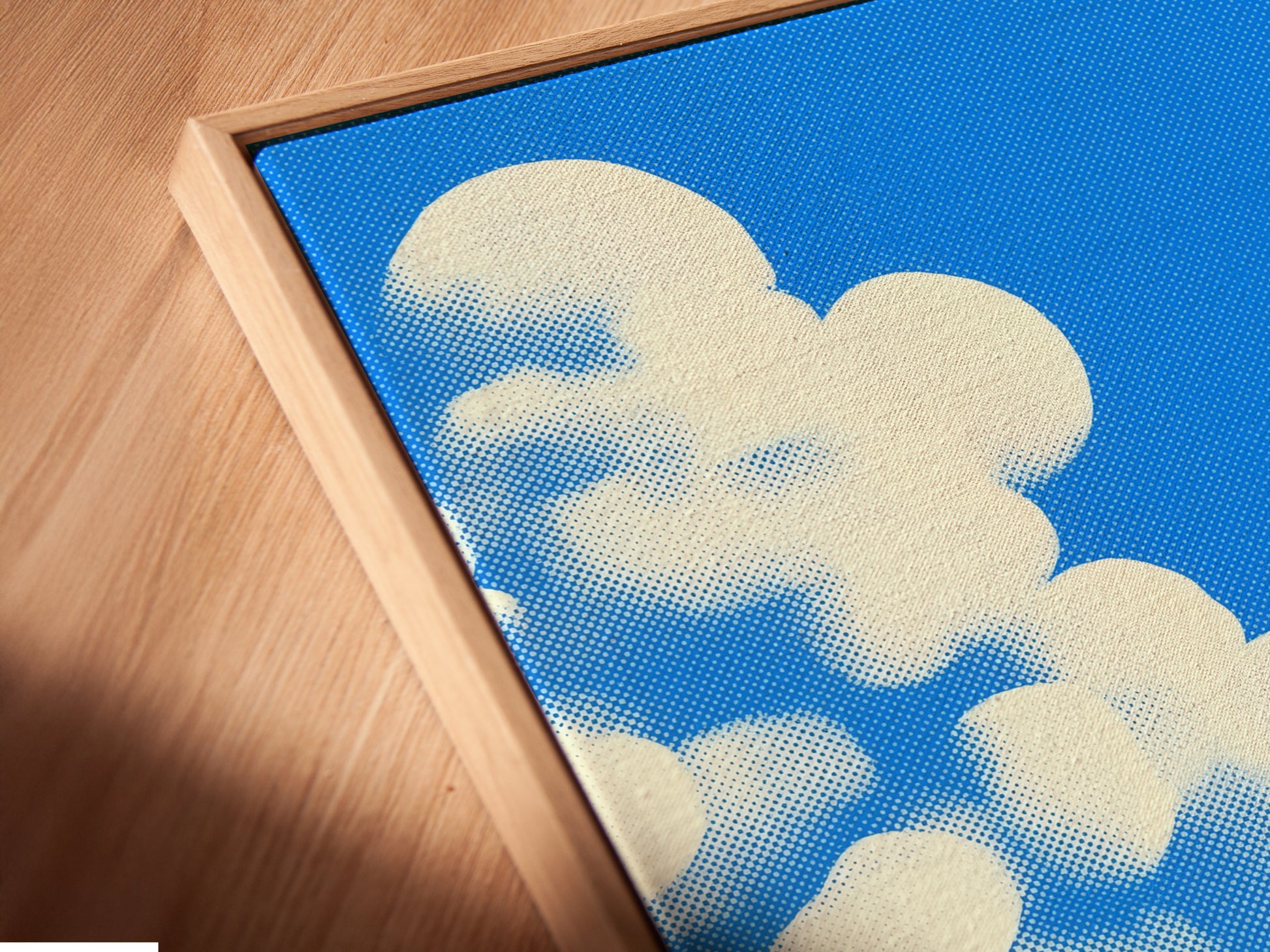 A close-up of the house and clouds canvas print. It is set in a floating frame. The floating frame gives the artwork a gallery-like appearance. Perfect for a playful artwork display.