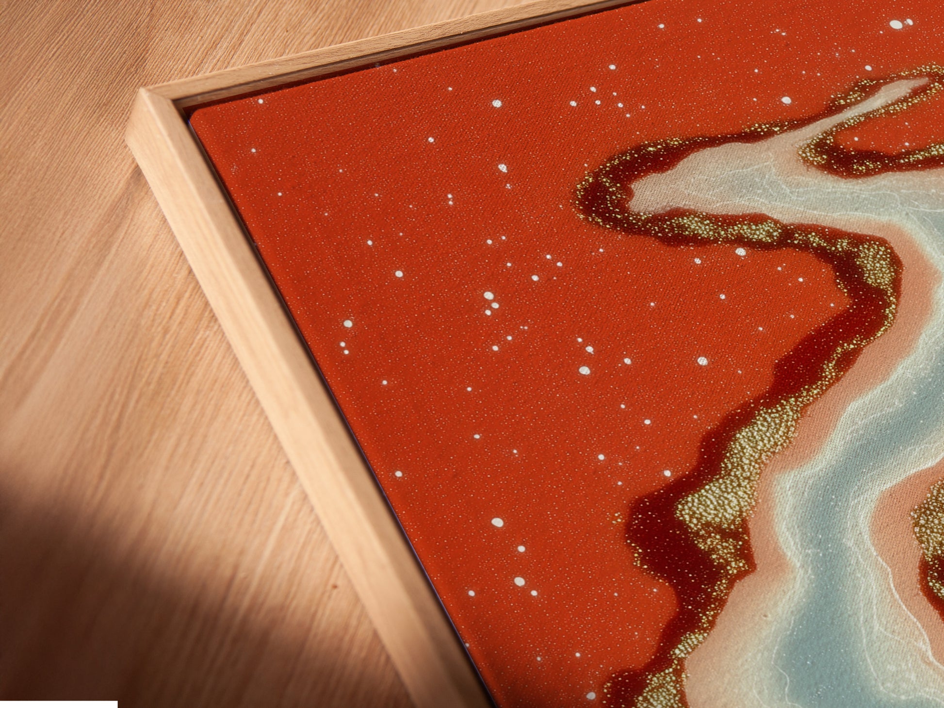 A close up shows the texture of this canvas print in a floating frame. Notice how the abstract river art seems to float. Coral orange and teal tones create a modern artwork. Perfect for adding depth and style to any room. See the quality craftsmanship.