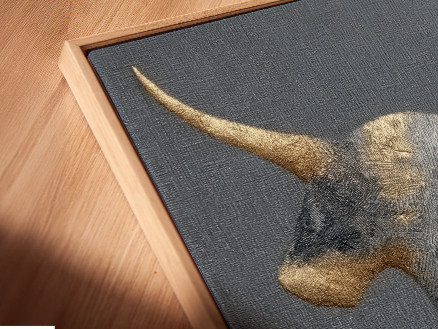 Here is a close-up of a canvas print in a floating frame. The golden bull artwork looks stunning. This modern farmhouse decor is perfect for study rooms. The minimalist art complements any space. Elevate your walls with this unique piece of abstract art. This is ideal for masculine spaces.