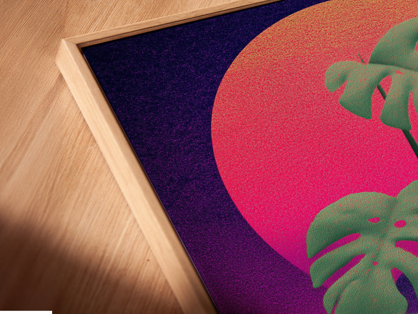 A close-up angled view of a canvas print. The monstera artwork is showcased in a floating frame. The floating frame enhances the artwork's depth. It adds a contemporary touch to any space.