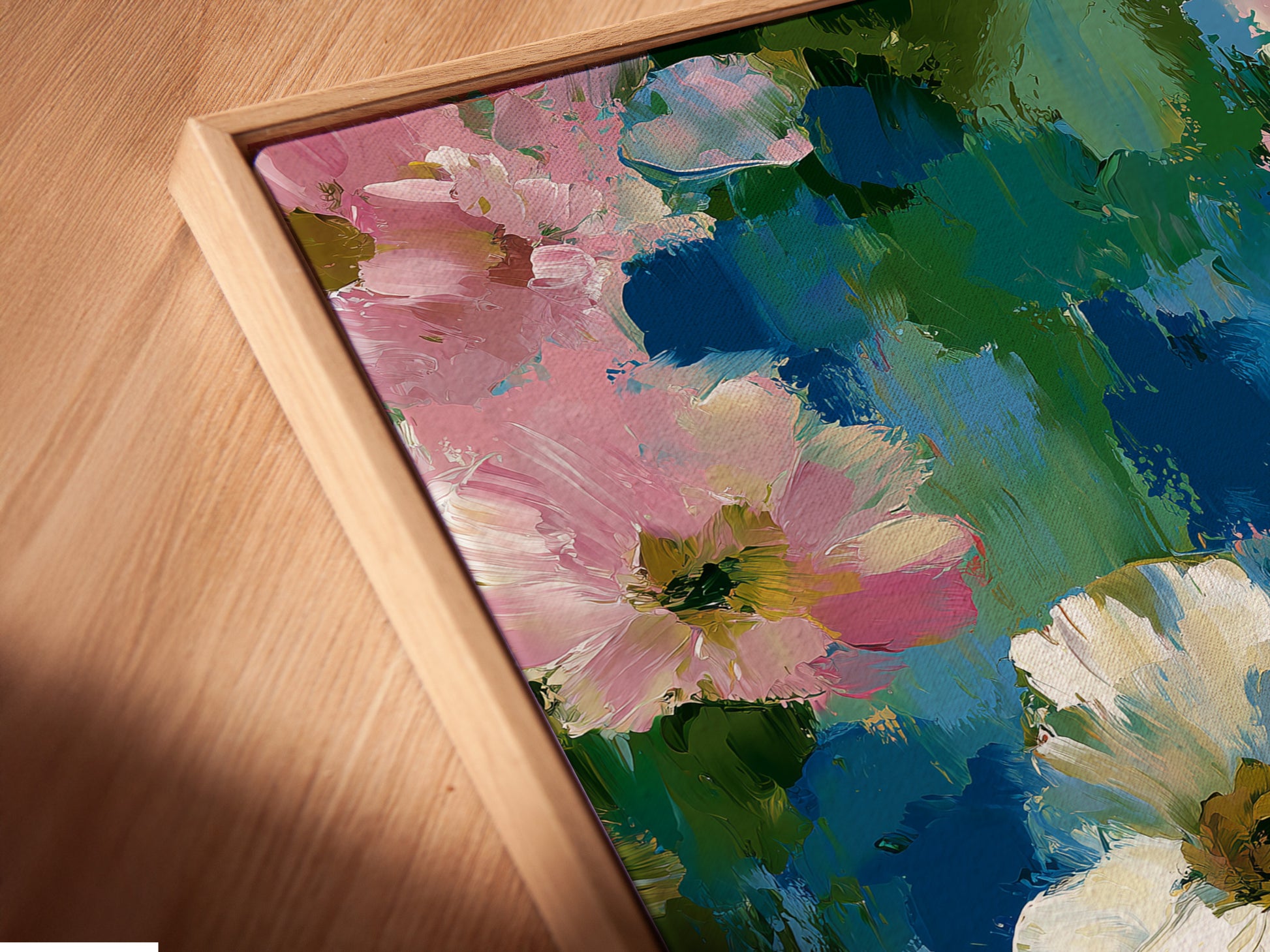 A close-up angled view of a floral canvas print in a floating frame. The pink and blue flower wall art is showcased beautifully. Impressionist botanical artwork that enhances bedroom decor. Perfect for adding a touch of spring. Ideal for cottagecore and contemporary spaces. Bring abstract flowers into your home. Shabby chic art for a refined aesthetic.