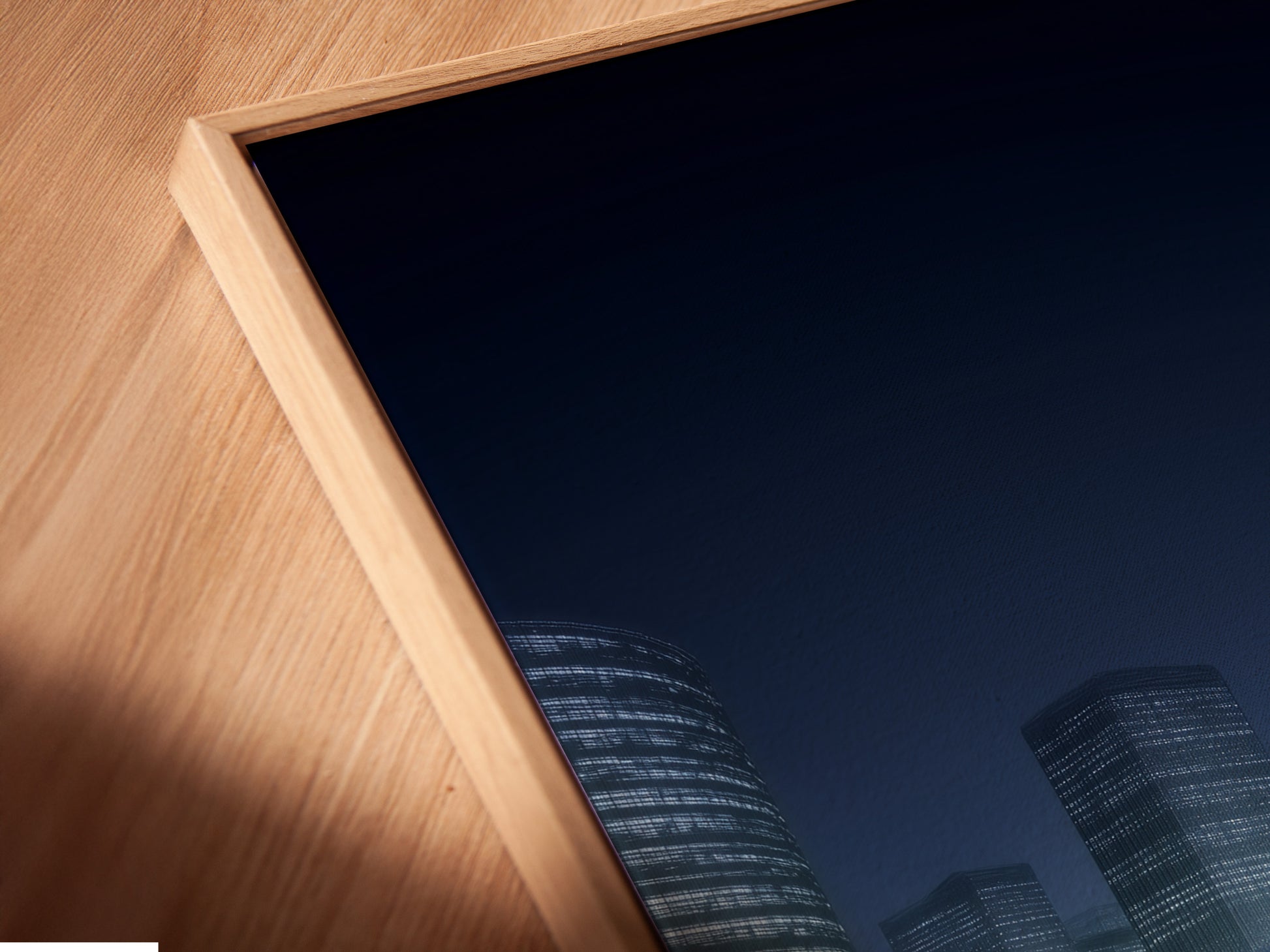 A close-up angled view of a canvas print featuring futuristic cityscape artwork in a floating frame. The modern urban scene is highlighted by digital city lights. The floating frame adds depth and dimension to the artwork. It is a stunning piece of contemporary wall decor.