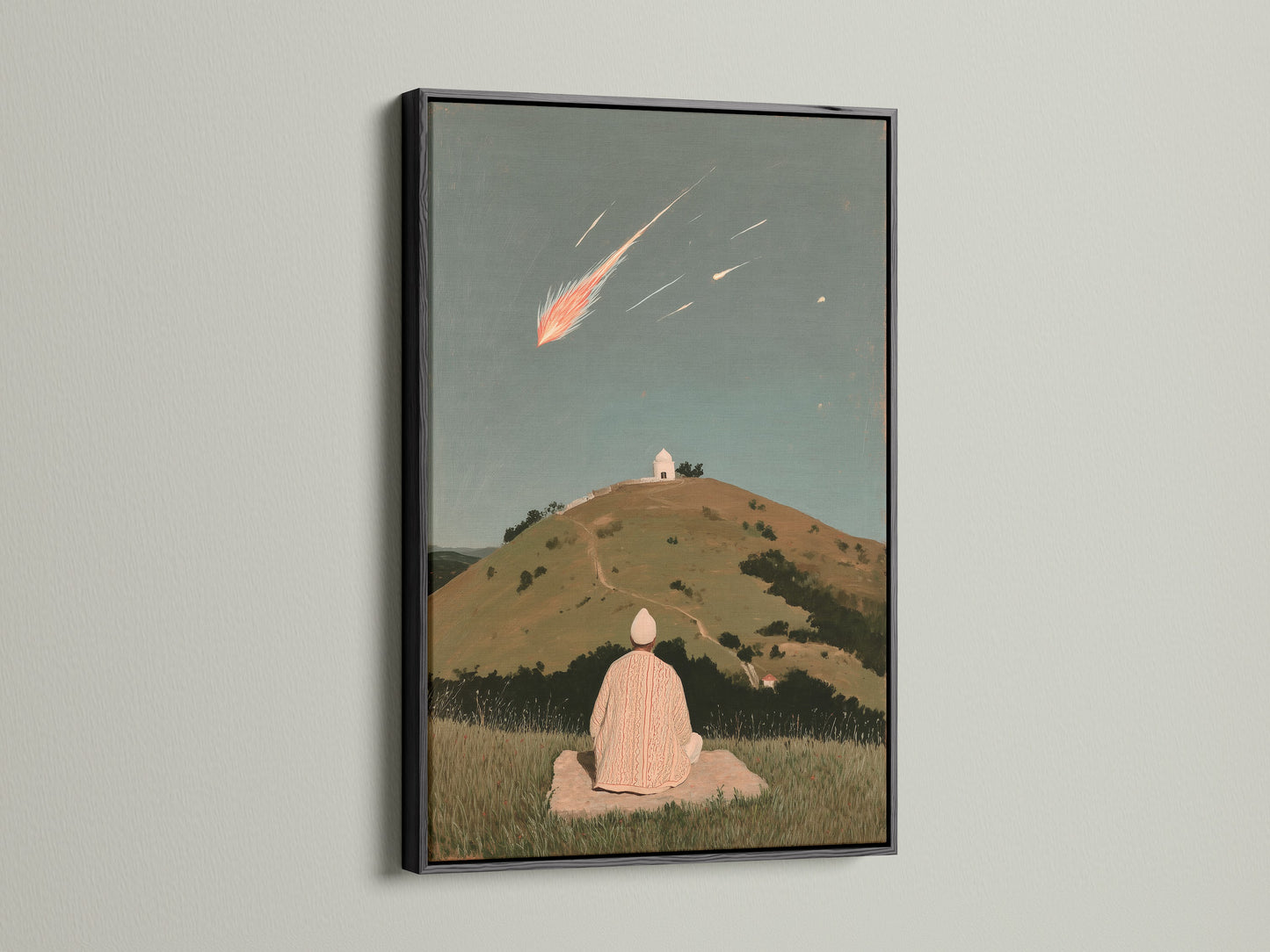 The Shooting Star canvas print is displayed in a sleek black frame. This spiritual artwork brings a sense of calm and wonder. The print features a person meditating on a hill under a shooting star. Black frame contrasts beautifully with the artwork.