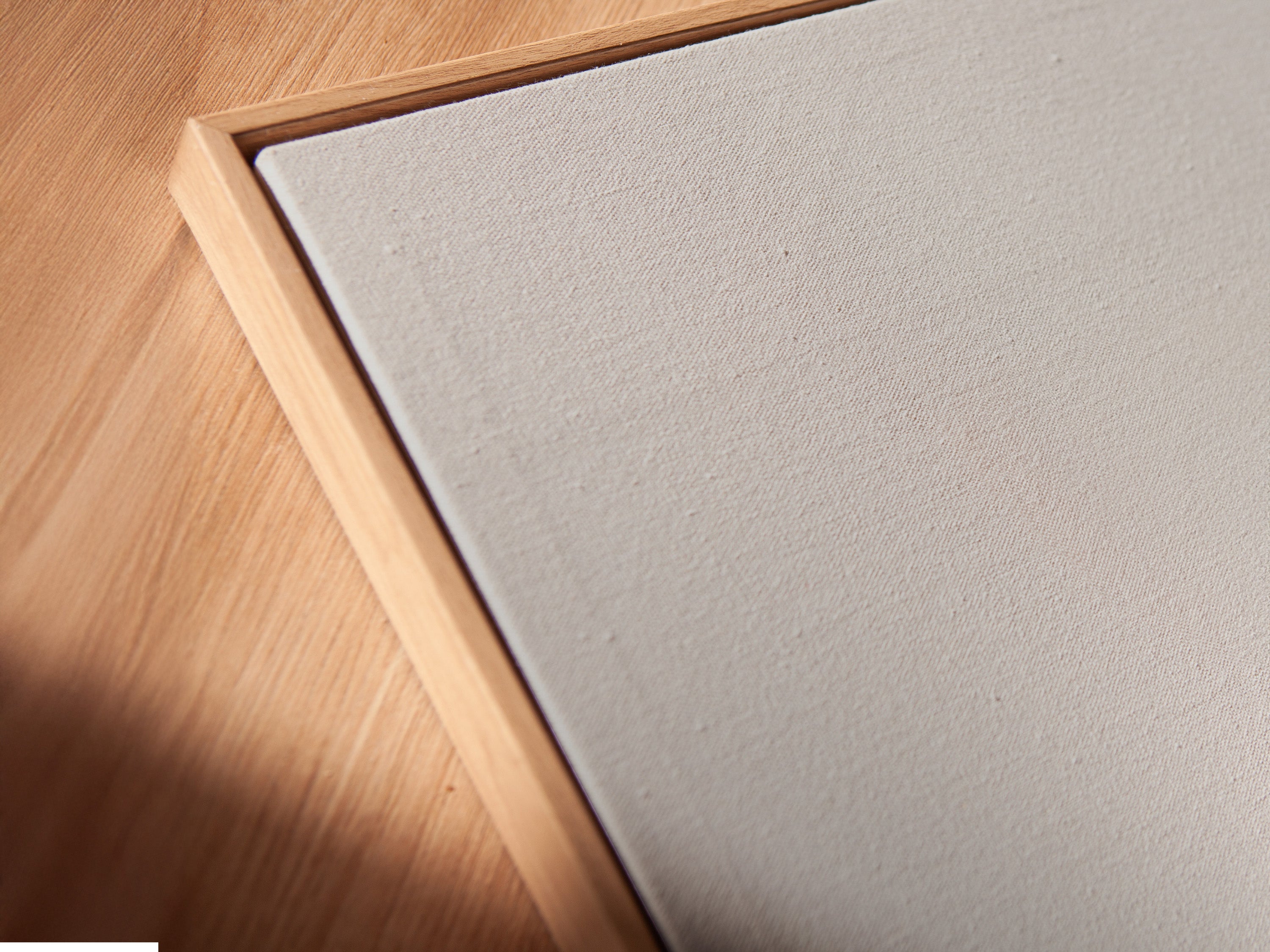 A close-up angled view shows a canvas print in a floating frame. It features minimalist solitude artwork. The foggy water reflection creates depth. Enhance your space with this modern piece.