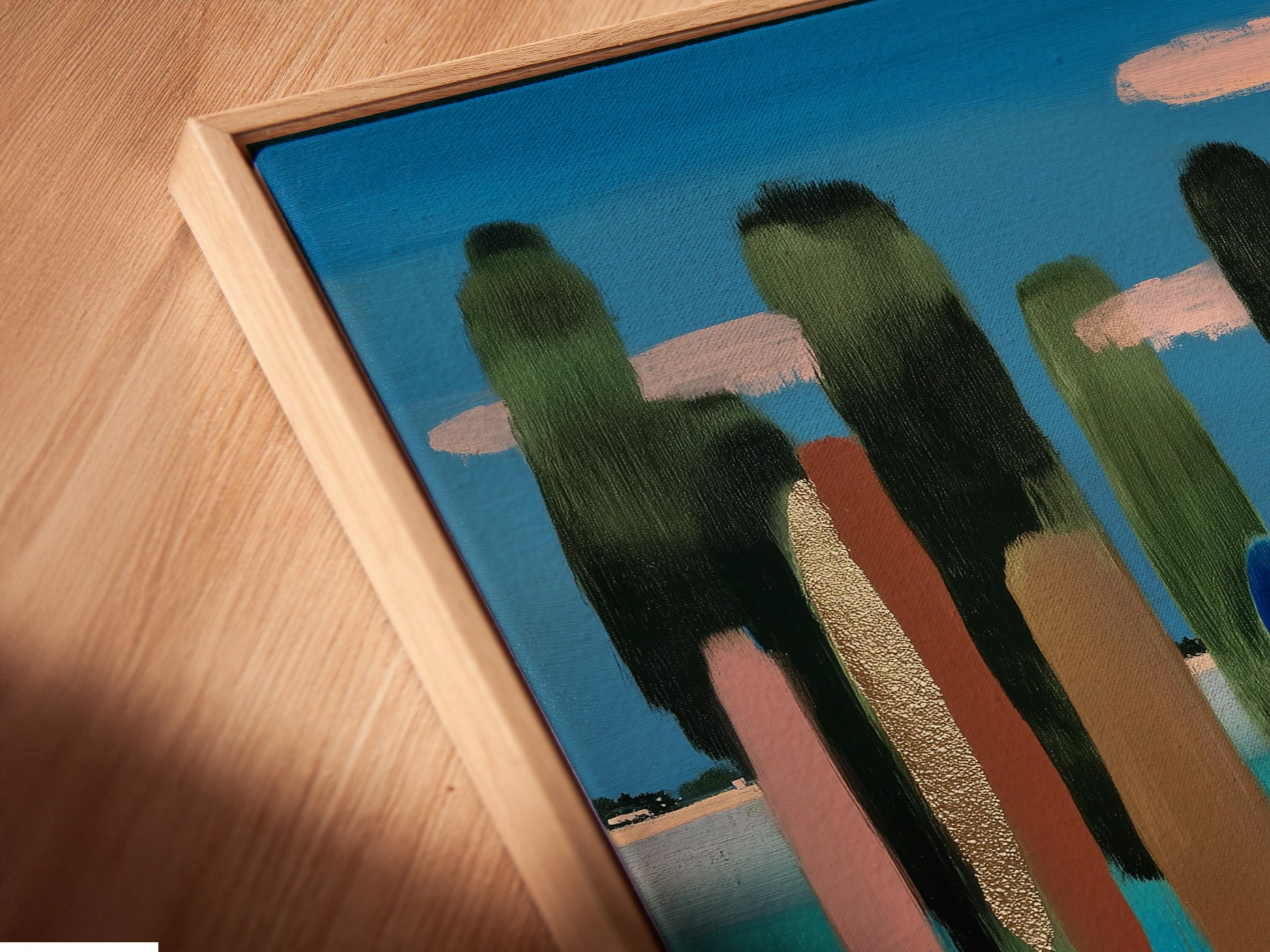 Close-up of a canvas print in a floating frame. The frame creates a unique shadow effect. This floating frame enhances the artwork. Notice the texture and detail of the canvas print. The artwork is a landscape.