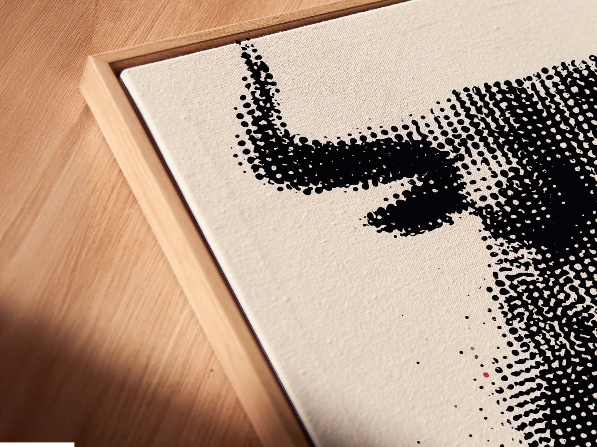 A close-up angled view of a canvas print in a floating frame. The bull artwork features a modern halftone print. The floating frame adds depth and dimension. This unique framing style enhances the artwork's contemporary look. It's perfect for creating a gallery-like feel in your home or office. Elevate your wall art today.