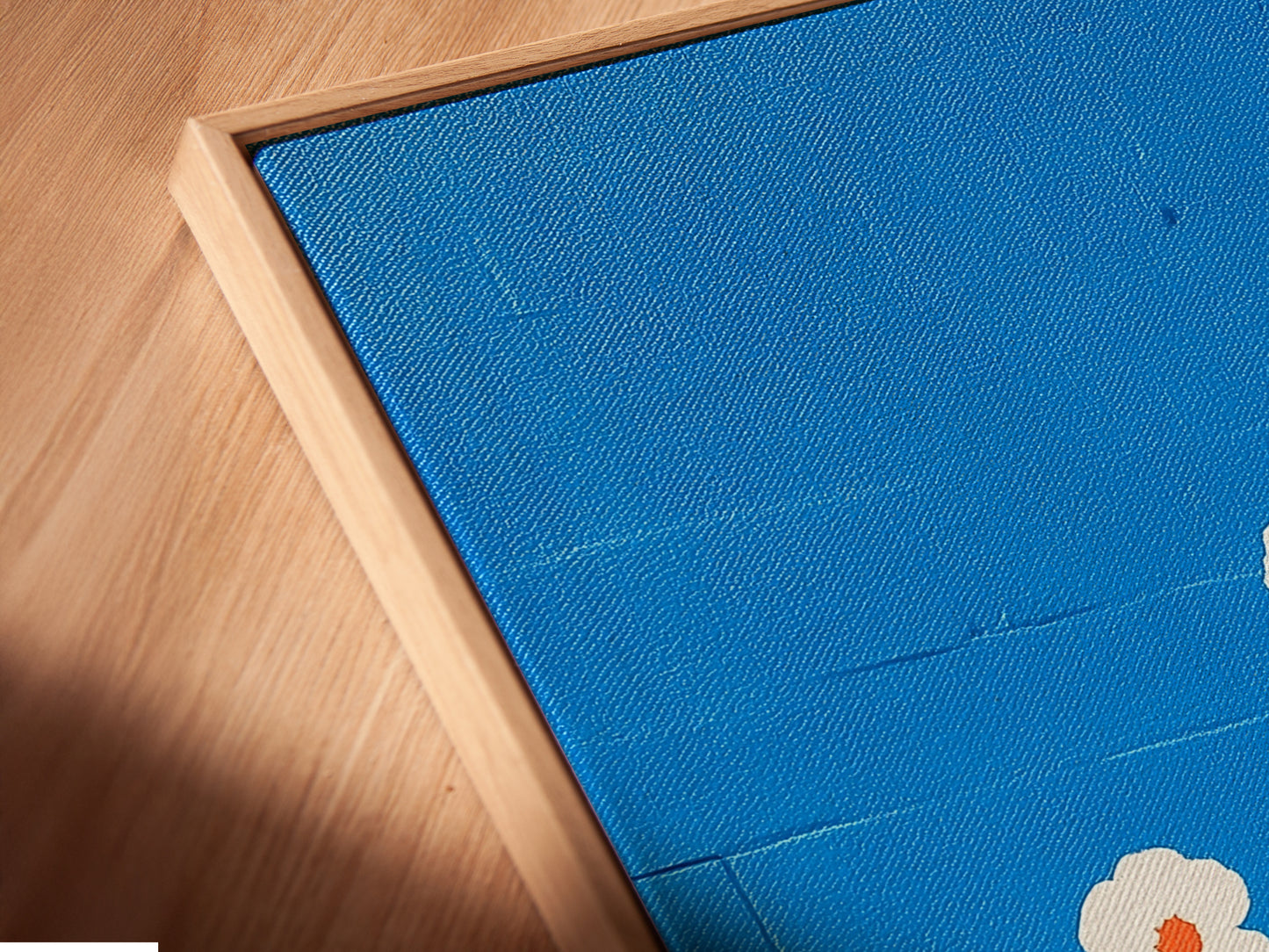 A close-up showcases the canvas print in a floating frame. The floral artwork has azure blue hues with botanical elements. It is a stylish choice for modern spaces. The floating frame adds depth.