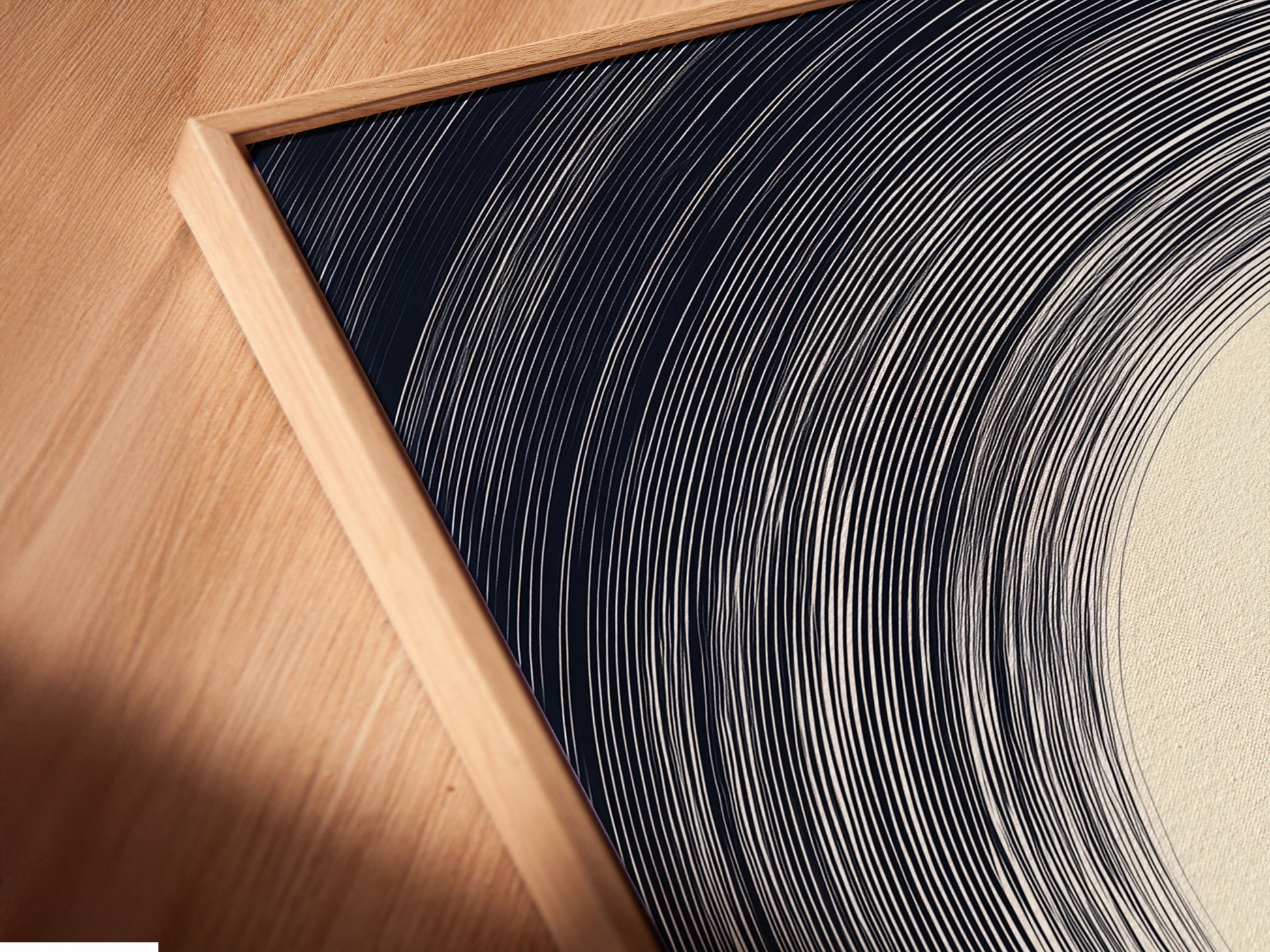 Angled close up shows a canvas print in a floating frame. The minimalist art features an abstract landscape. The colors are beige black and white. The floating frame enhances the artwork's contemporary appeal. A sophisticated choice for modern wall decor.