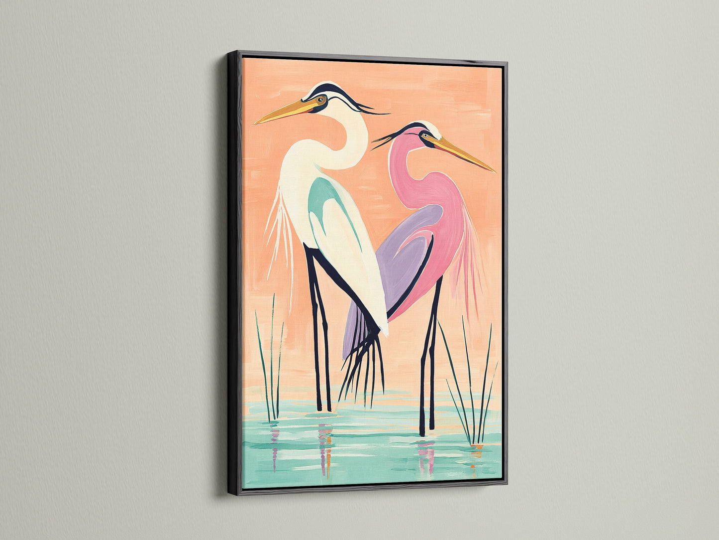 A coastal bird wall art piece featuring herons is displayed in a black frame. This black frame provides a bold contrast to the peach and teal tones in the heron art. Ideal for creating a focal point in any room. This artwork is perfect for homeowners renters interior designers and business owners.