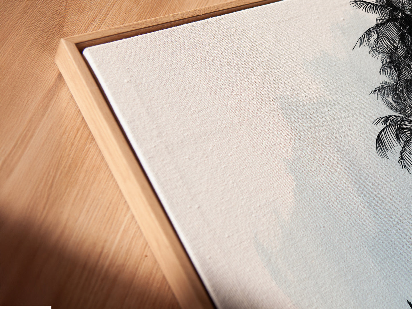 A close up angled view reveals a canvas print in a floating frame. The minimalist seascape artwork features a sailboat and sunlit tree. The floating frame enhances the art adding depth and sophistication. Perfect for coastal or minimalist decor. Explore our range of framed art prints for your home or office.