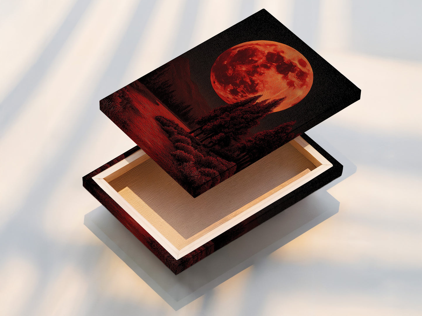 A stretched canvas print displays the red moon landscape artwork. The gothic wall art is ready to hang. The stretched canvas provides a professional and polished look for your celestial decor. Buy it now!