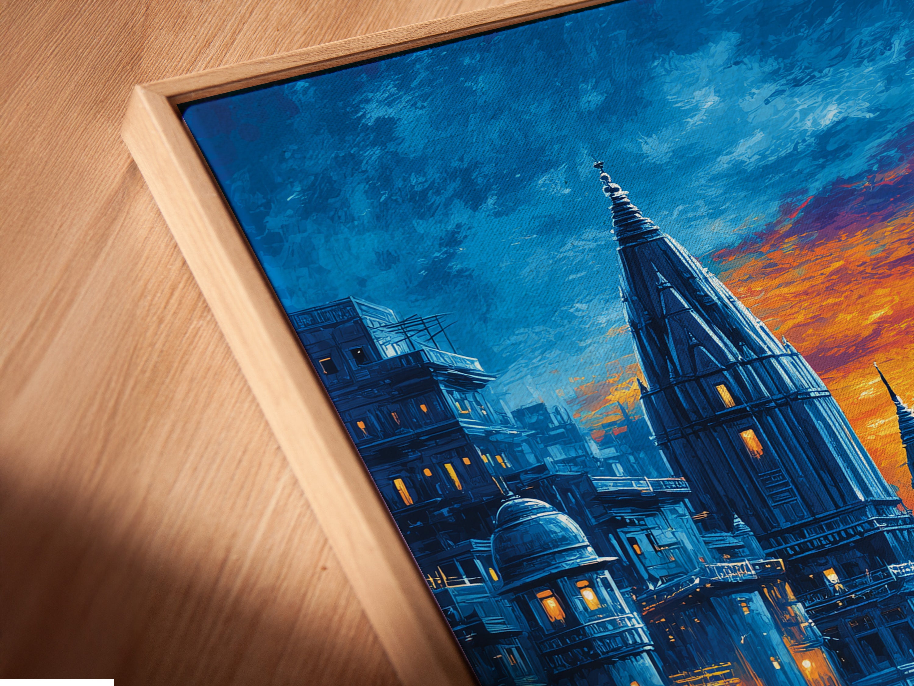 A close up angled view of the Varanasi Sunset Wall Artwork in a floating frame. The Indian temple artwork appears to float adding a modern touch. This sacred river print enhances any space with its spiritual wall art. The blue and orange hues create a calming effect. Perfect for meditation rooms.