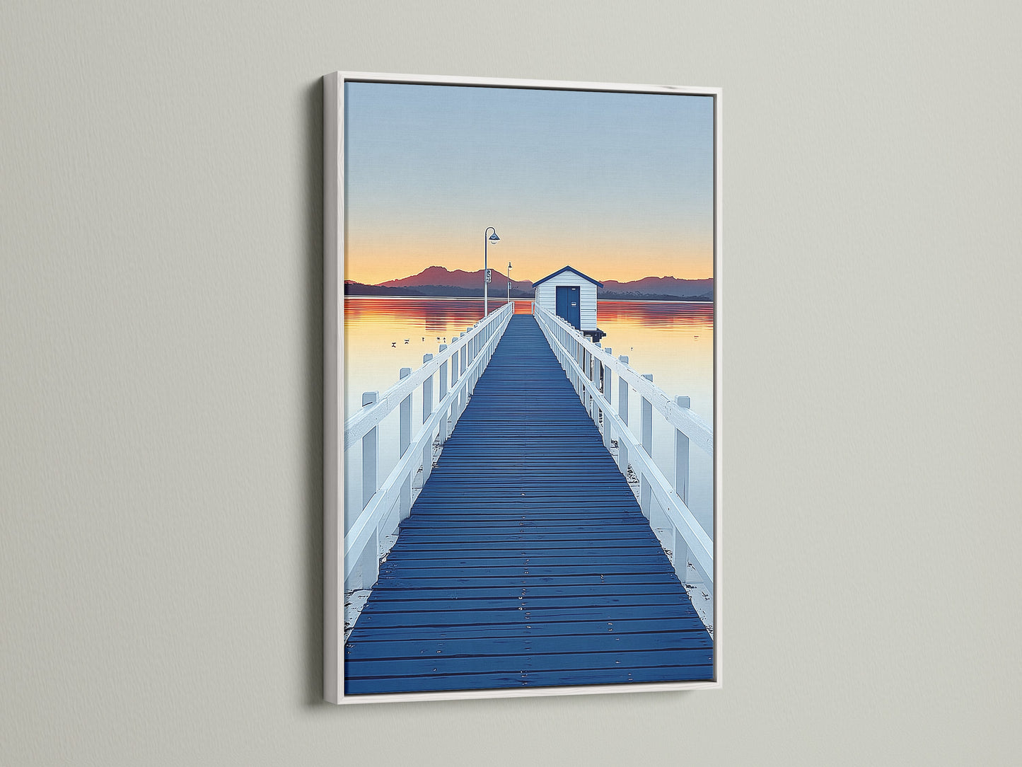 Elevate your space with dock sunset artwork. This artwork features a blue pier wall art print in a white frame.  The frame enhances the coastal scenery photography. Add a touch of modern art to your home decor.