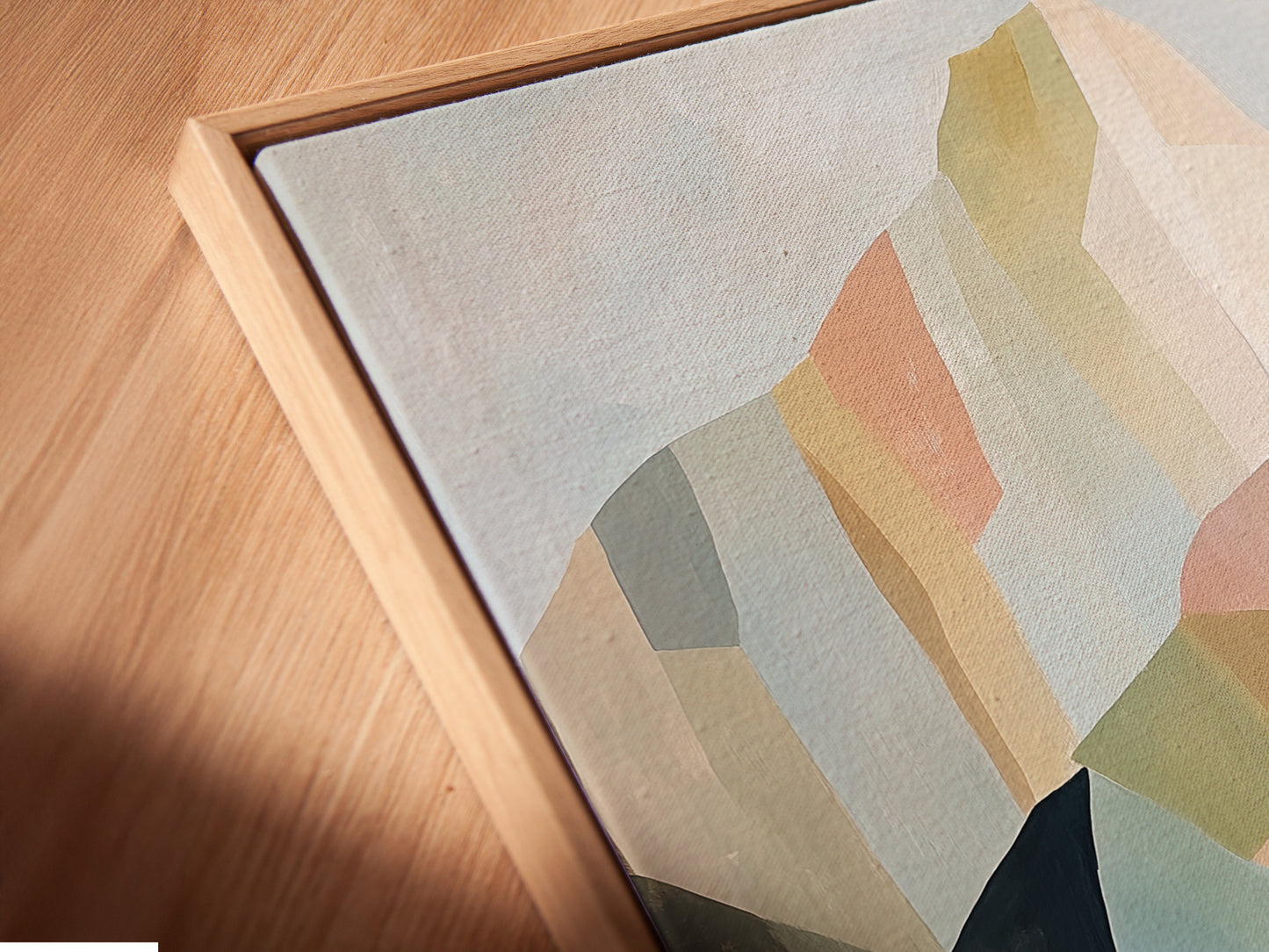 Angled close up of a canvas print featuring abstract mountain artwork in a floating frame. The contemporary wall art complements minimalist and modern aesthetics. Elevate your space today.