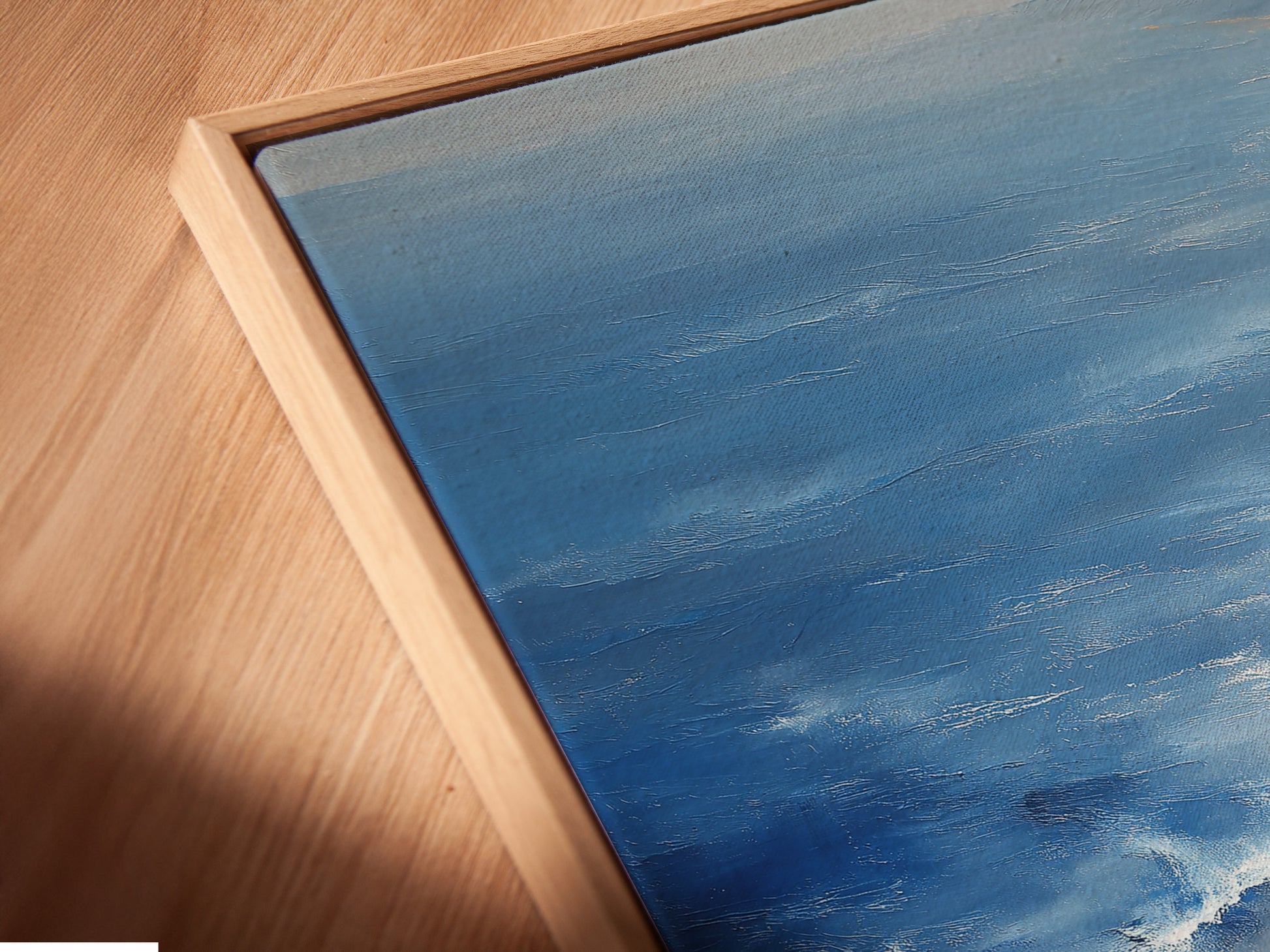 Angled close up of a Beach Walk canvas print. The artwork is set in a floating frame. The floating frame enhances the coastal wall art. Ocean waves are vividly depicted. Perfect for adding a minimalist touch to bedroom decor.