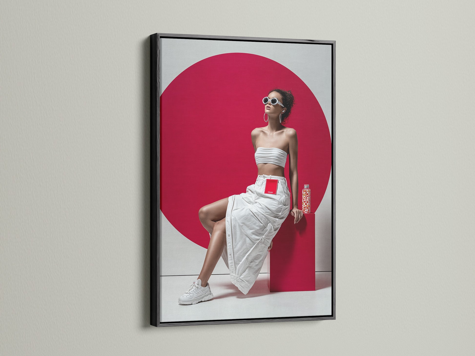 Modern fashion artwork displayed in a sleek black frame. The pop art canvas features a woman in a white ensemble with a striking red background. The black frame adds a touch of sophistication. A great piece for contemporary art lovers.