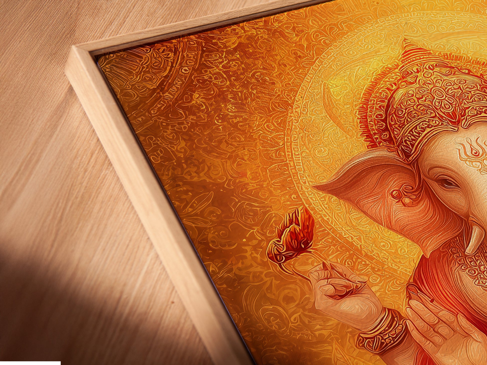 Close-up of Ganesha artwork in a floating frame. This canvas print shows the intricate details of the Hindu God. The spiritual art is in golden orange tones. This art is perfect for meditation rooms and yoga studios.