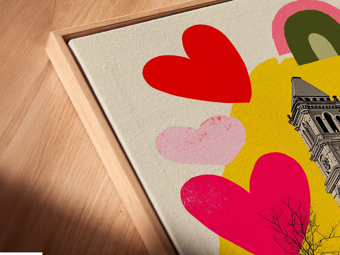 A close-up angled view of a canvas print in a floating frame. The art features a clock tower. It also has colorful hearts and rainbows. The floating frame enhances the artwork. It provides a modern gallery look. Discover the unique appeal of our floating frame canvas prints.
