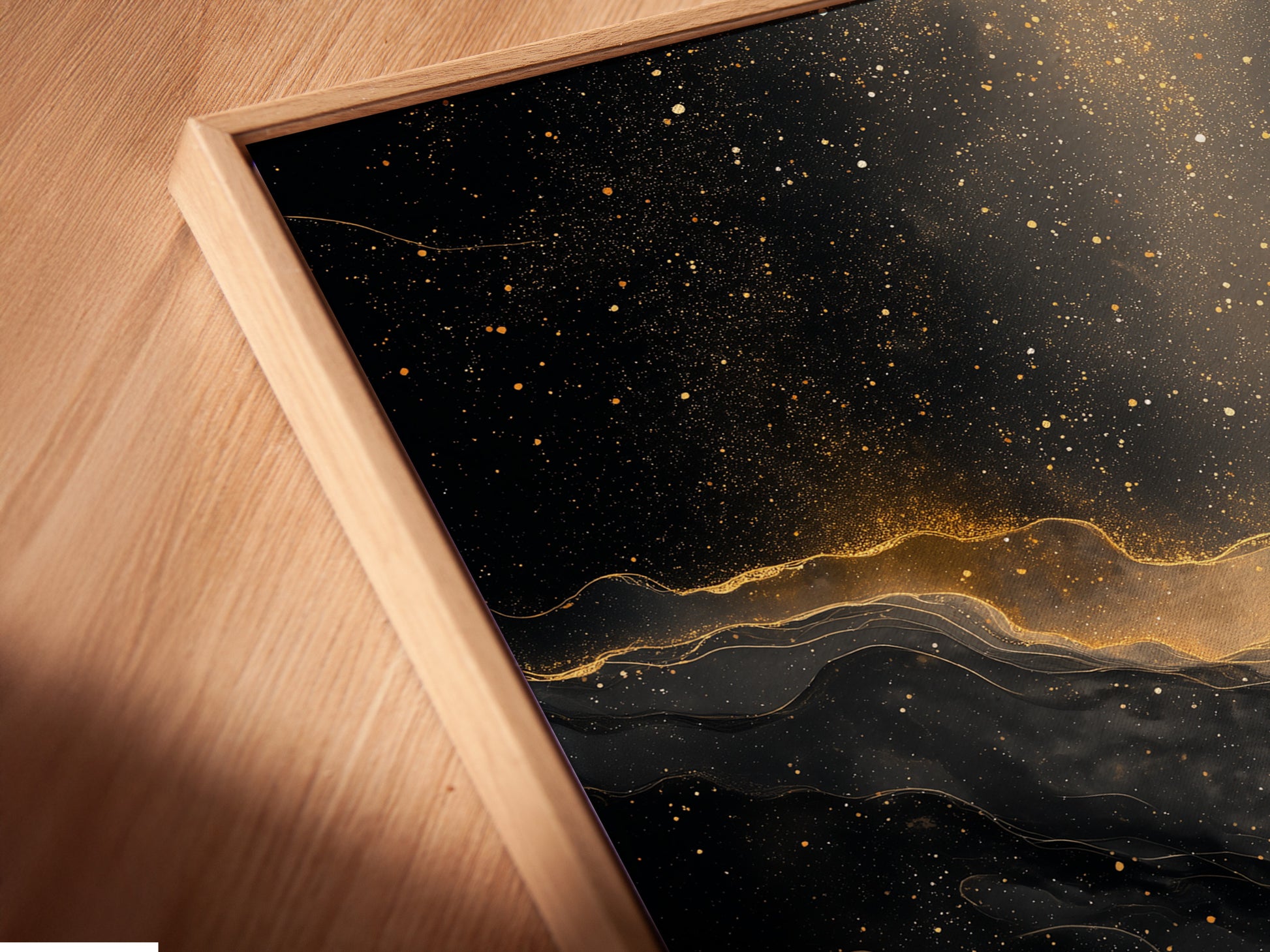 A close up of a canvas print in a floating frame. The art is abstract black and gold. The floating frame gives the art a modern look. It creates a shadow effect. The canvas print adds texture to the artwork. This is a stylish piece for any home.