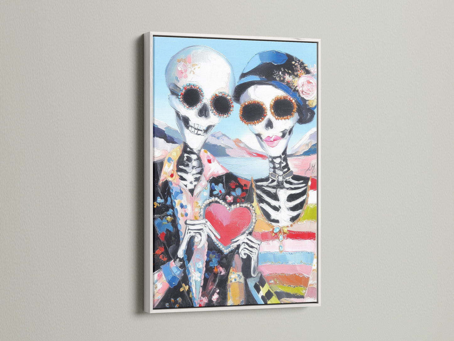 Day of the Dead wall art in a white frame. The sugar skull couple poster brings a vibrant folk art touch. The colorful art and gothic decor make it ideal for a home altar or eclectic living room.