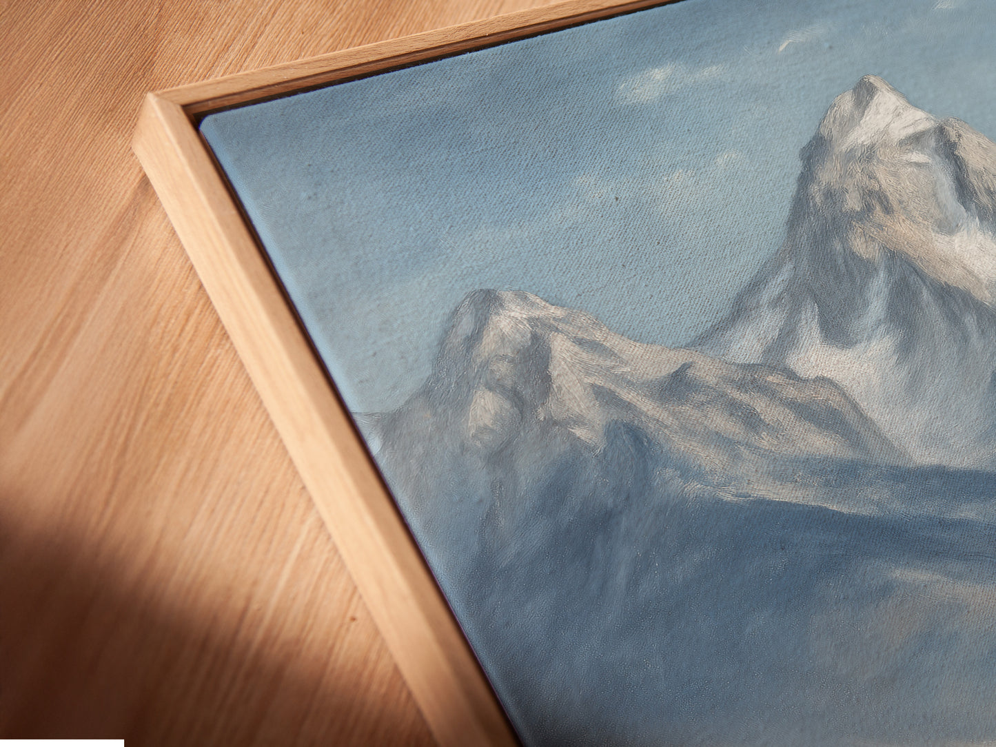 A close-up angled view reveals a canvas print of mountain and highland cattle in a floating frame. This modern framing style elevates the rustic farmhouse wall art. The artwork enhances the countryside feel. Ideal for homeowners and renters seeking unique wall decor.