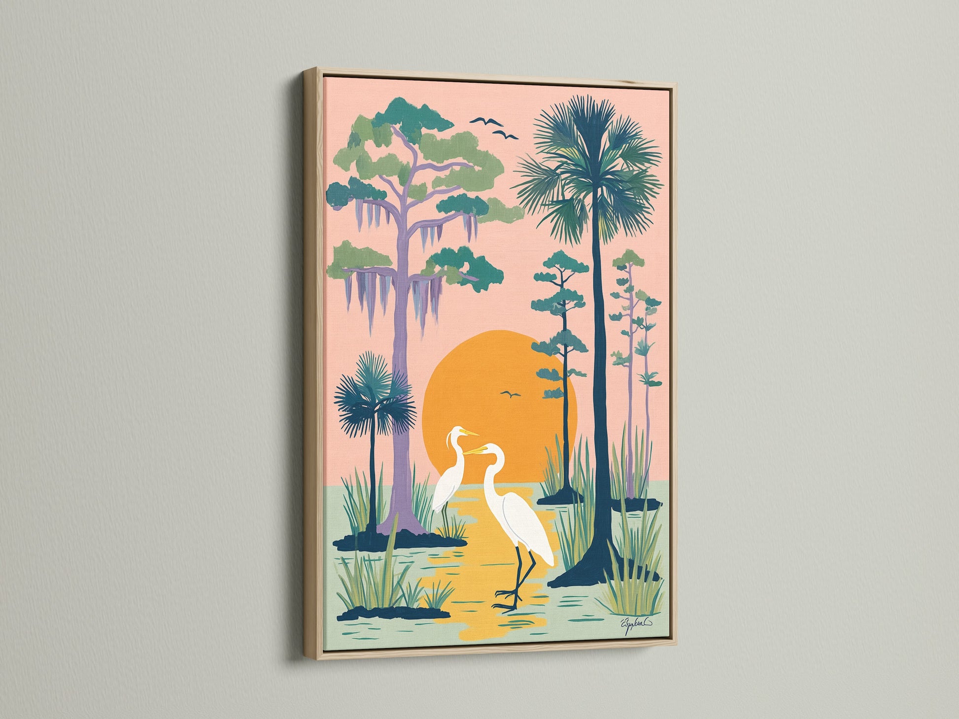 Framed heron artwork in an oak frame. This coastal wall art features two herons in a peach colored swamp. Teal and green trees line the horizon. Bring the beachy artwork into your home. This Florida landscape artwork makes a perfect gift.