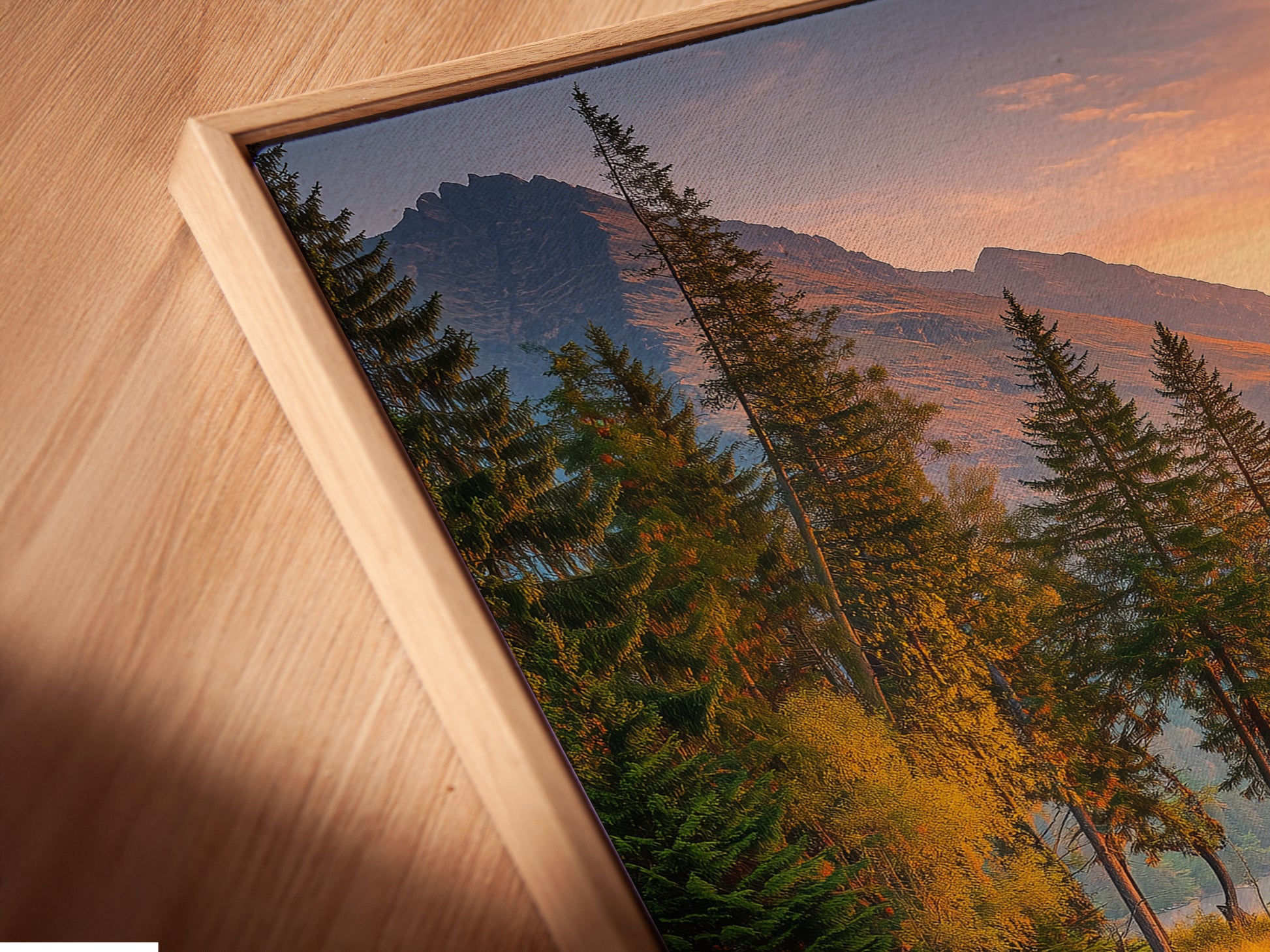 Angled close up of a mountain lake canvas print in a floating frame. This landscape artwork brings nature indoors. Perfect for cabin decor and nature enthusiasts. The floating frame adds a modern touch. Enhance your living space with this unique piece of nature photography and forest artwork.