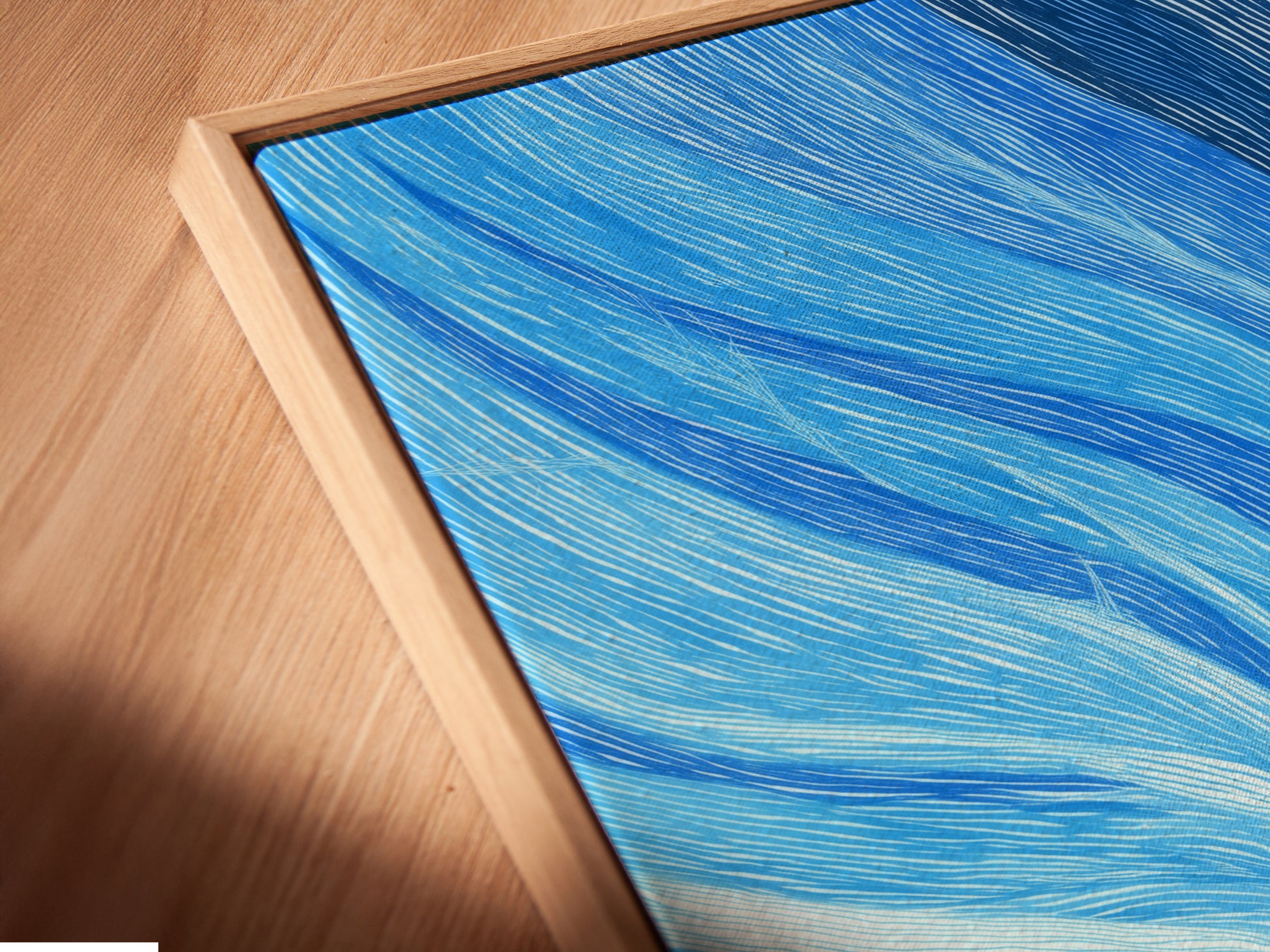Close up of a canvas print in a floating frame. The floating frame gives a gallery like appearance. The Abstract Tree artwork features blue and coral tones. The modern nature art is perfect for wall decor. Add a contemporary touch to any space.