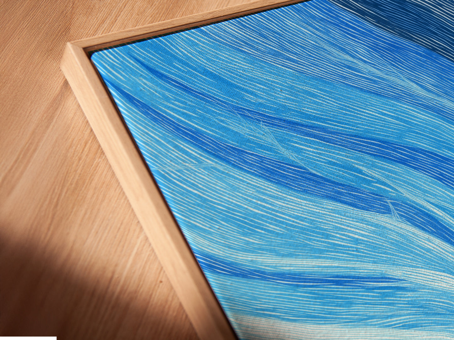 Close up of a canvas print in a floating frame. The floating frame gives a gallery like appearance. The Abstract Tree artwork features blue and coral tones. The modern nature art is perfect for wall decor. Add a contemporary touch to any space.