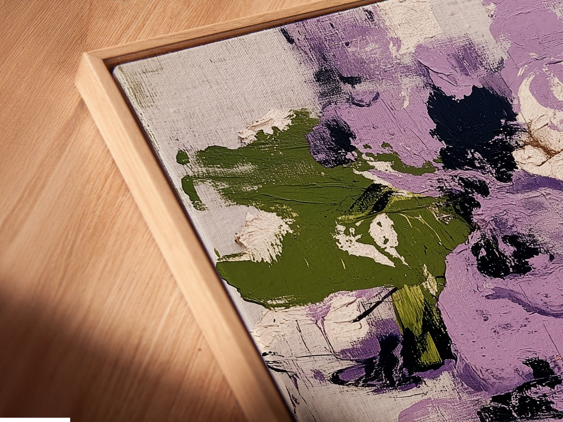 A close-up angled view of a canvas print in a floating frame. The artwork showcases abstract floral patterns with purple and green hues. This contemporary botanical print adds a modern touch to any space. The floating frame enhances the artwork's visual appeal and style.