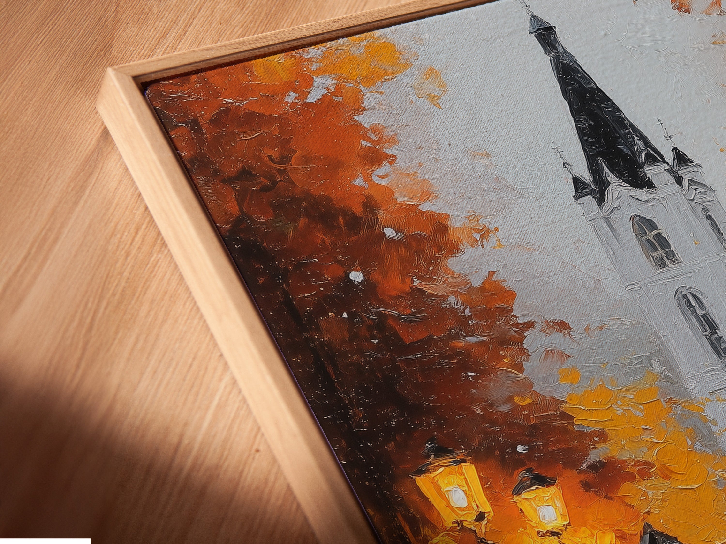 Close-up angled view of canvas print in a floating frame. The artwork features a building a person with an umbrella. The floating frame enhances the artwork's appeal. A stylish addition to any room.