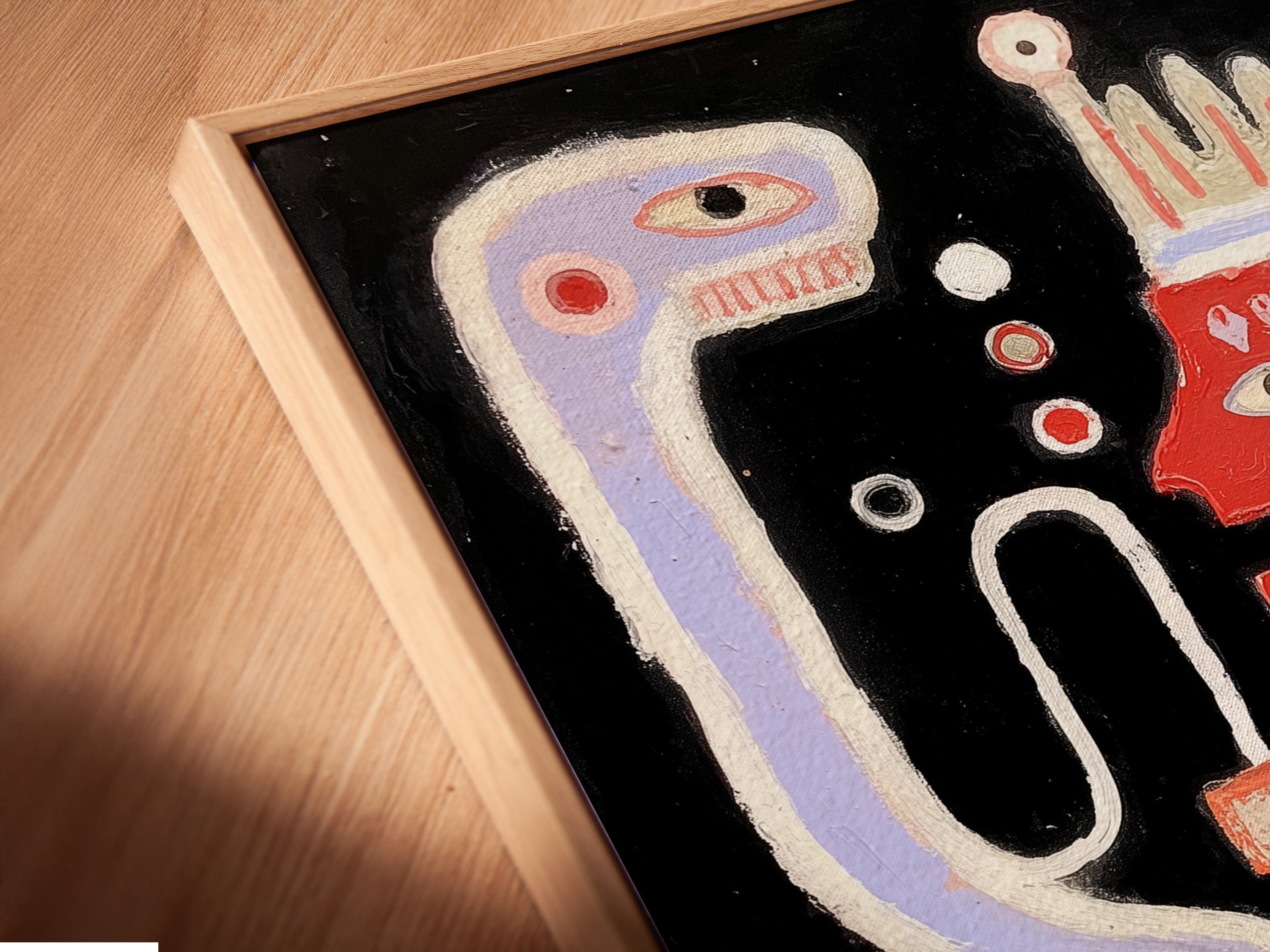 A close-up angled view shows a canvas print in a floating frame. This abstract monster art is a playful and modern addition to any space. The contemporary artwork is ideal for living room wall art. It will add a touch of color.