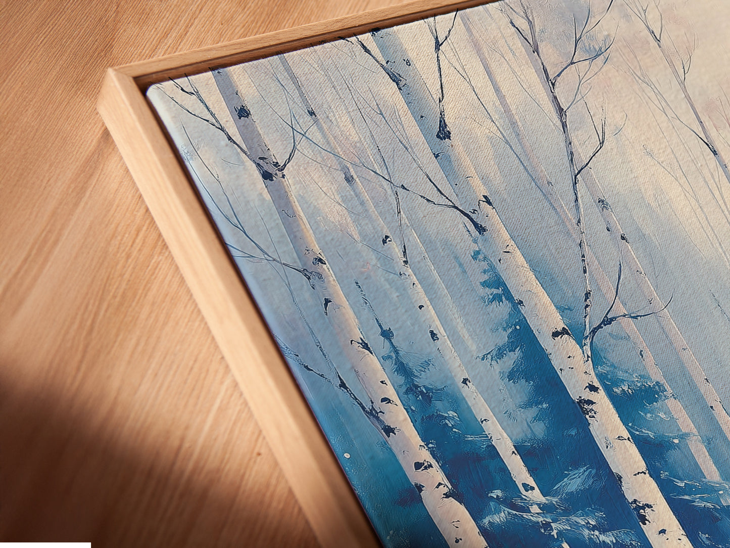 Angled close up of a canvas print in a floating frame. The winter forest artwork is beautifully displayed. This birch tree art enhances any room. Discover our fine art prints today.