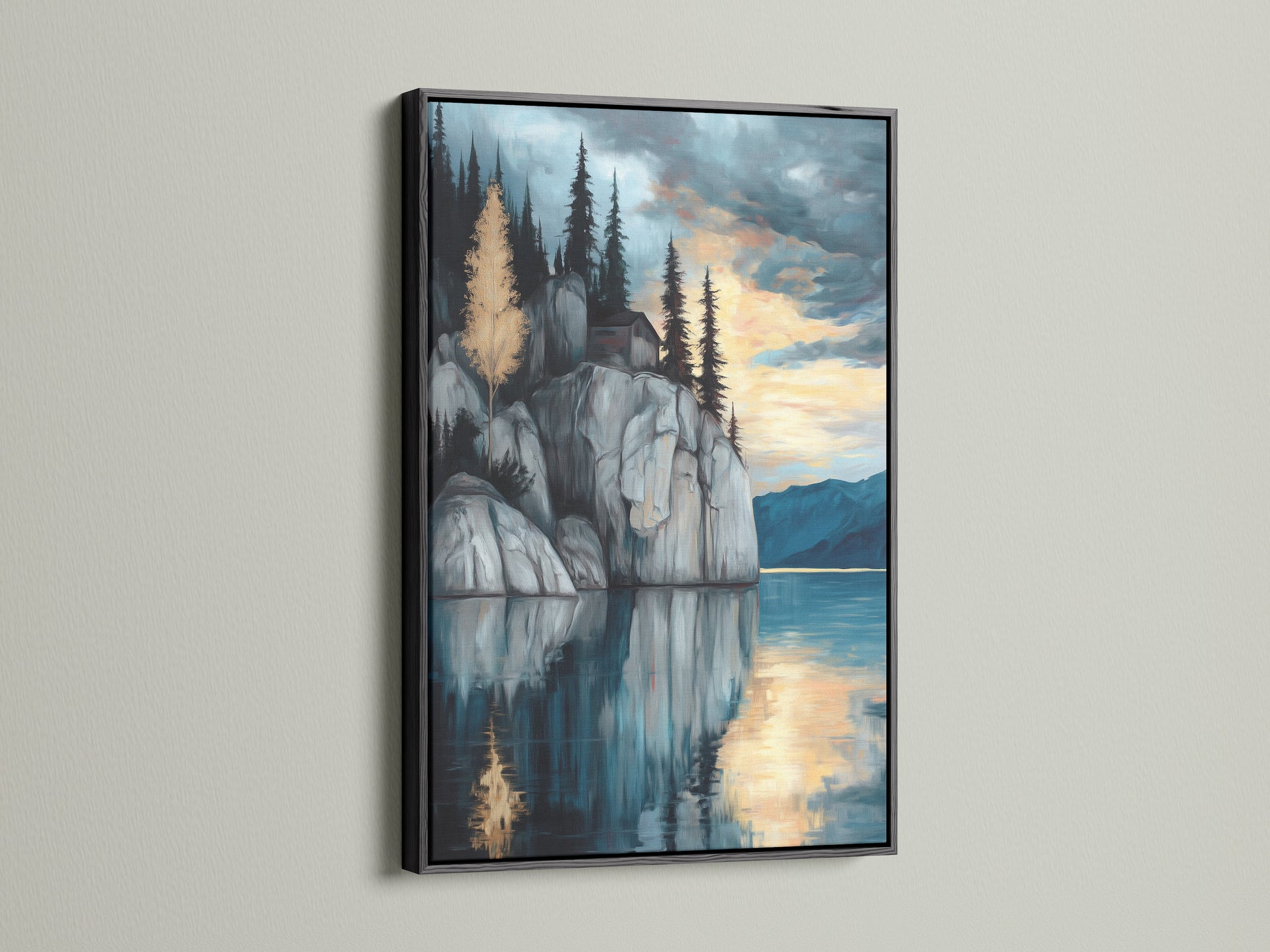 Lakeside Cliff canvas print with a black frame. Ideal serene mountain wall art for a modern study room. This moody landscape artwork presents a tranquil scene. Blue and gray hues enhance the reflective art. The mountain painting and water reflection make this a scenic art print.