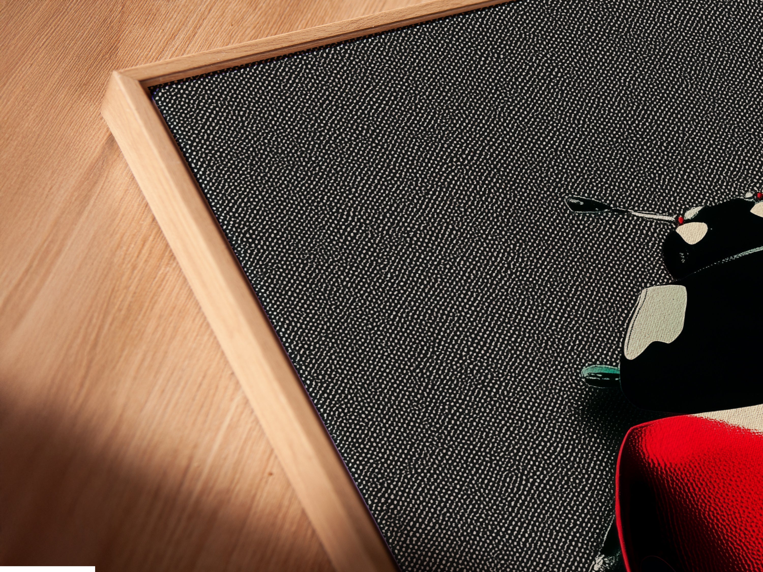 Angled close-up of a ladybug canvas print in a floating frame. The red and black insect wall art creates a modern contemporary look. The floating frame enhances the artwork. Perfect for adding a unique touch to your home decor.