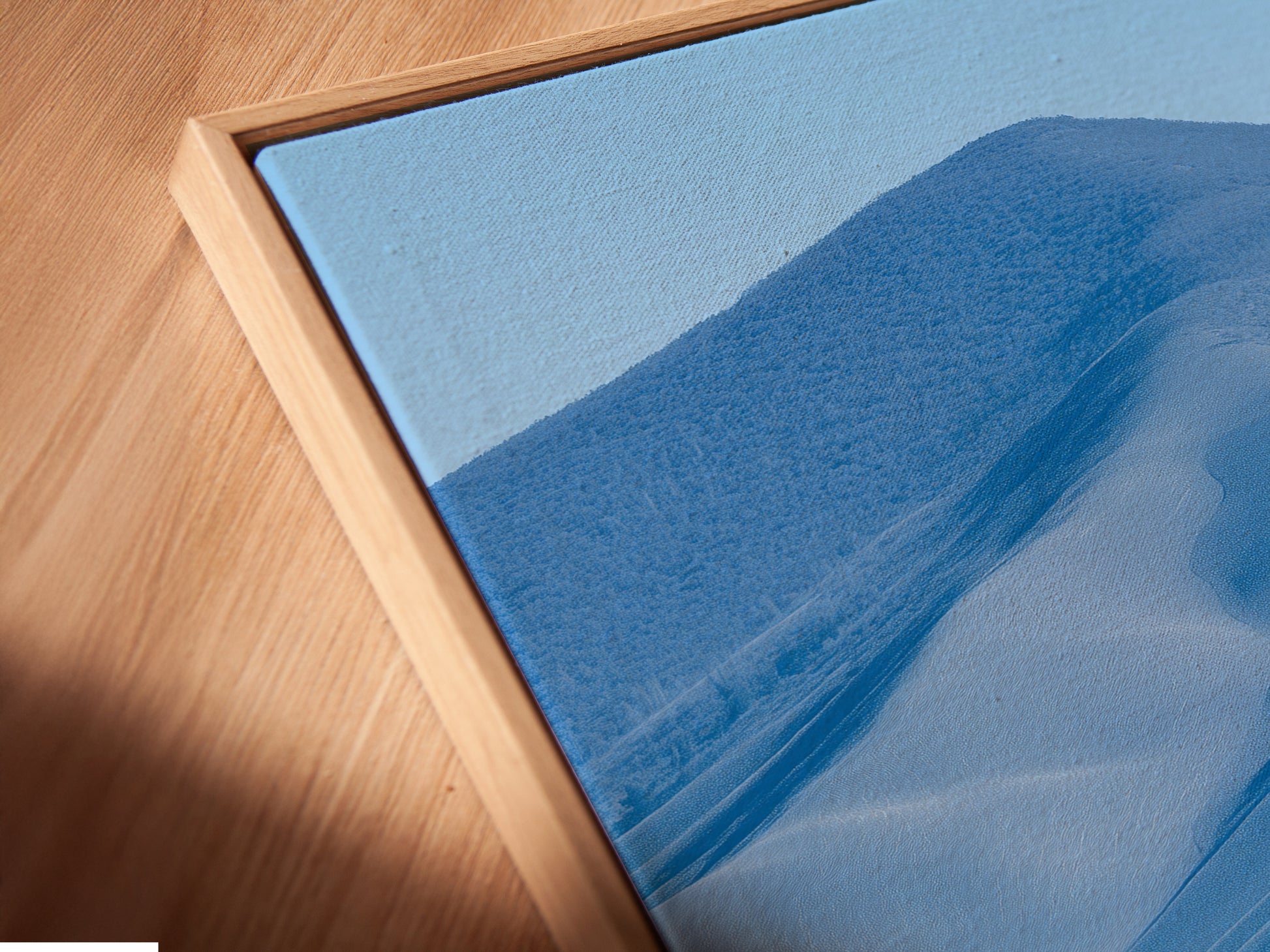 Angled close up of a Tuscany landscape canvas print in a floating frame. This Italian countryside artwork enhances any space. The farmhouse scenery adds rustic charm. Perfect for living room wall art or bedroom wall decor. Elevate your home with neutral tone art.