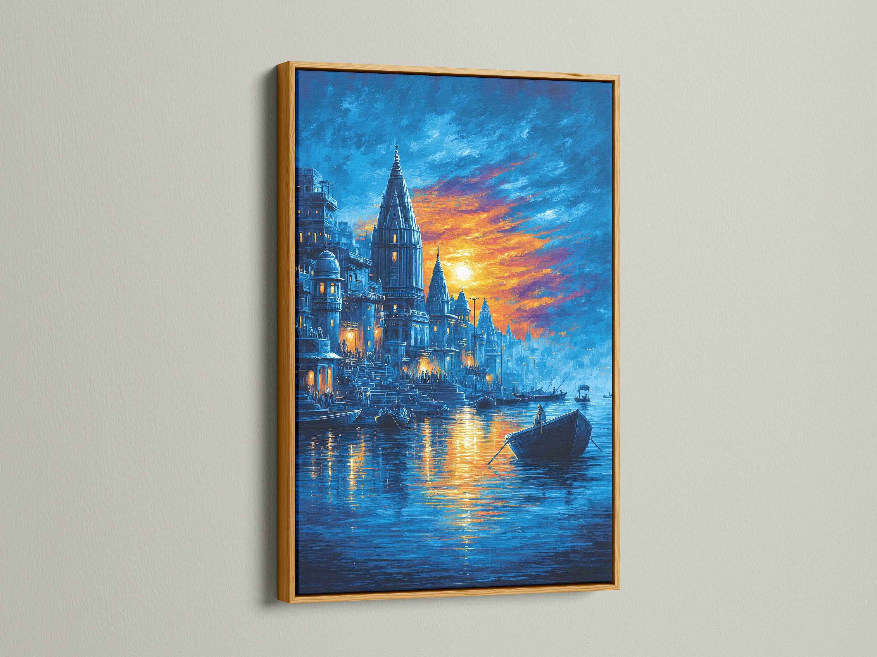 Varanasi Sunset Wall Artwork is luxuriously displayed in a gold frame. This Indian temple art brings a touch of opulence to any wall. The sacred river print shines with the golden accent. Perfect for adding spiritual wall art to your living room. The blue and orange artwork complements bohemian decor.