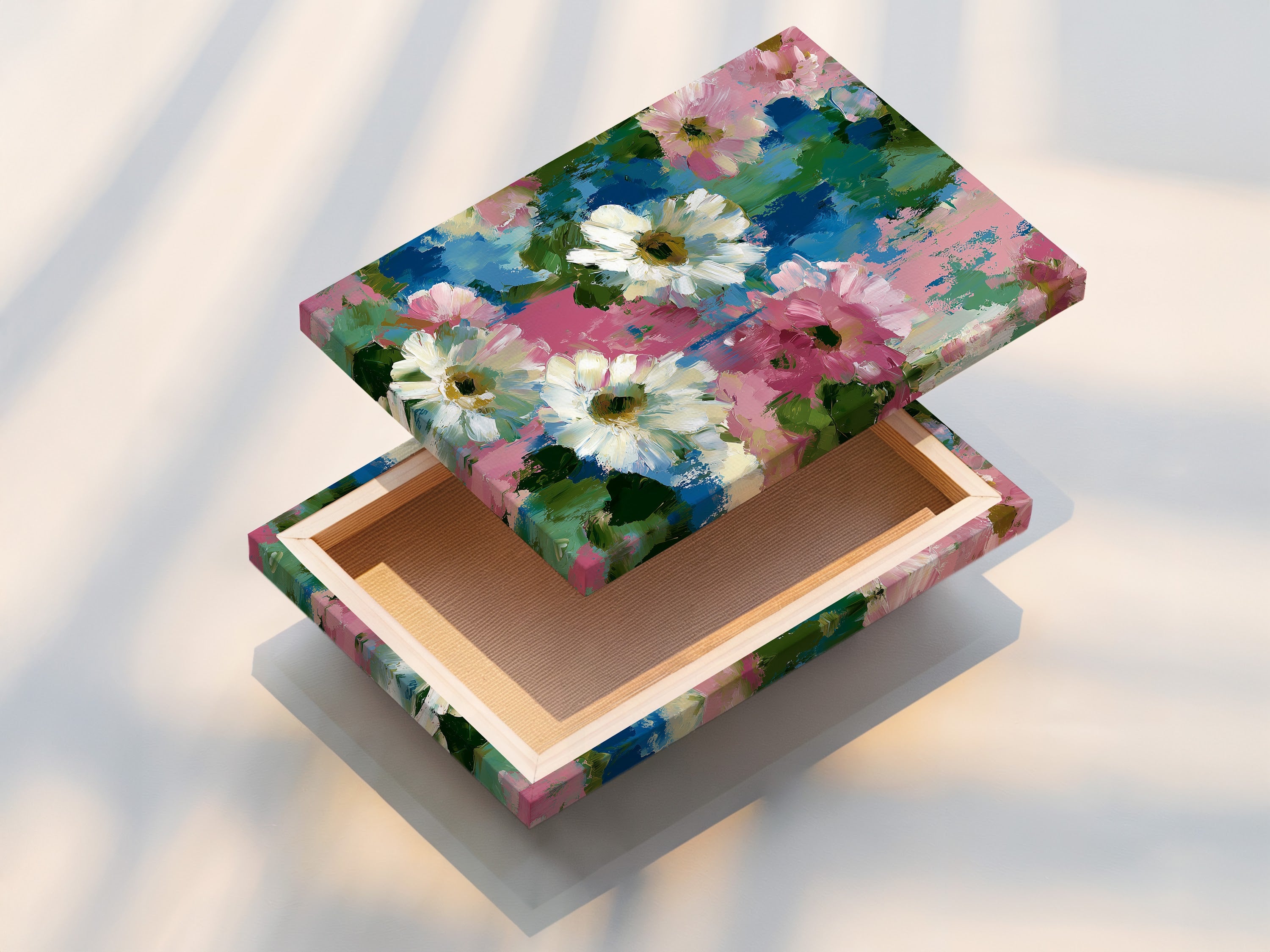 A stretched floral canvas print showcasing pink and blue flower wall art. This impressionist botanical artwork is perfect for bedroom decor. Ideal for homeowners and apartment dwellers. This daisy art print adds a cottagecore touch. Bring spring wall art into your home. Abstract flowers create visual interest. Garden art print for a charming aesthetic.