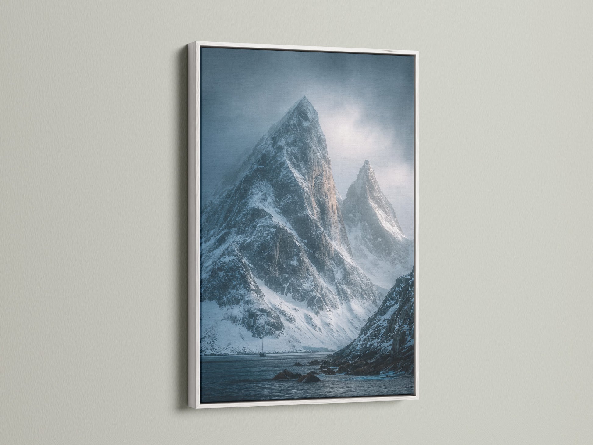 Mountain Peak Canvas Print with a white frame. The snowy landscape wall art features moody blue photography. This nature print enhances office wall decor. Discover how this wilderness art transforms your space.