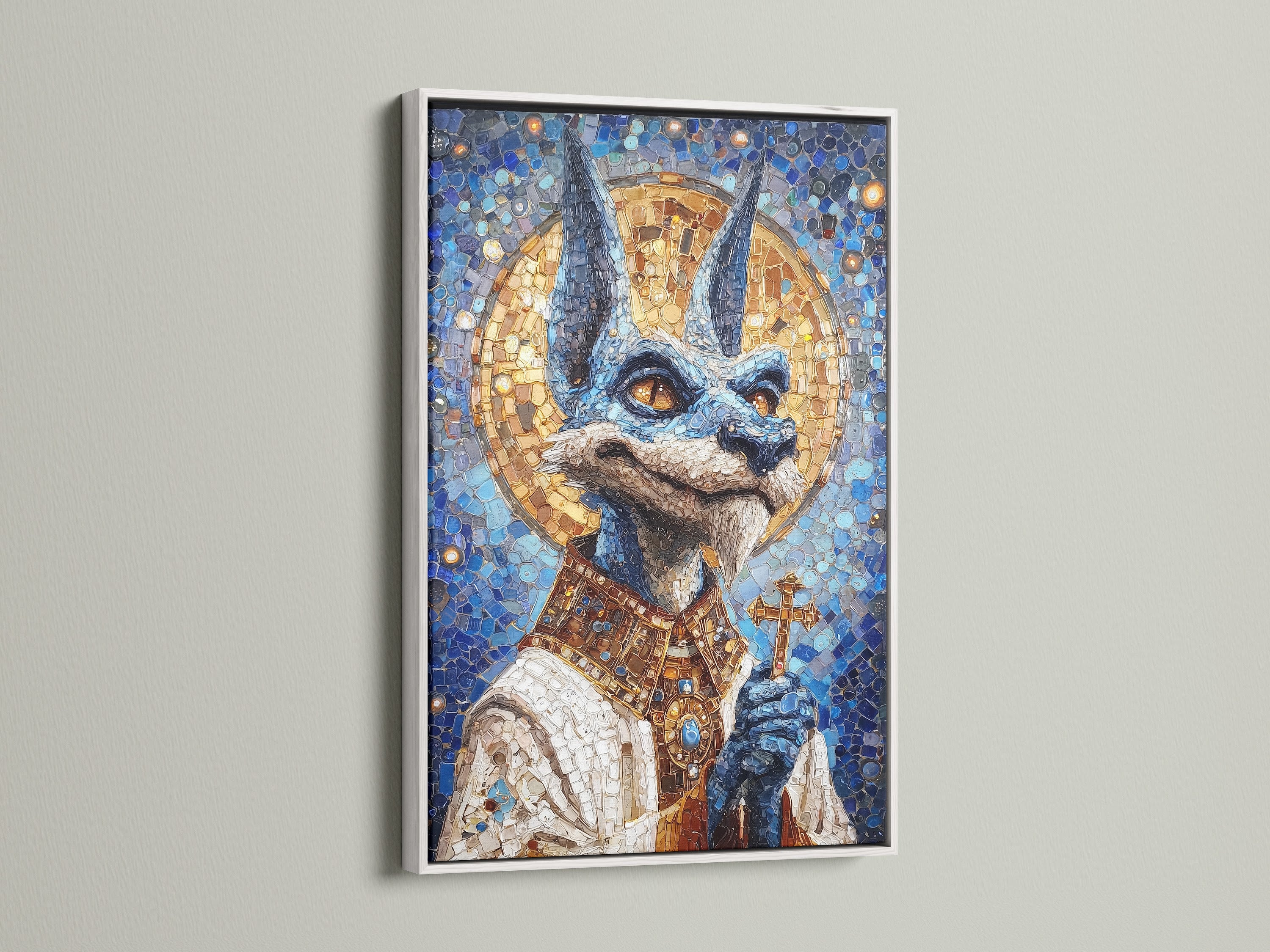 Anubis Mosaic Artwork Print with a white frame. The artwork is an Egyptian God Wall Art piece. It features blue and gold religious imagery. Perfect gothic art for bedroom wall decor.  The frame provides a clean modern look.