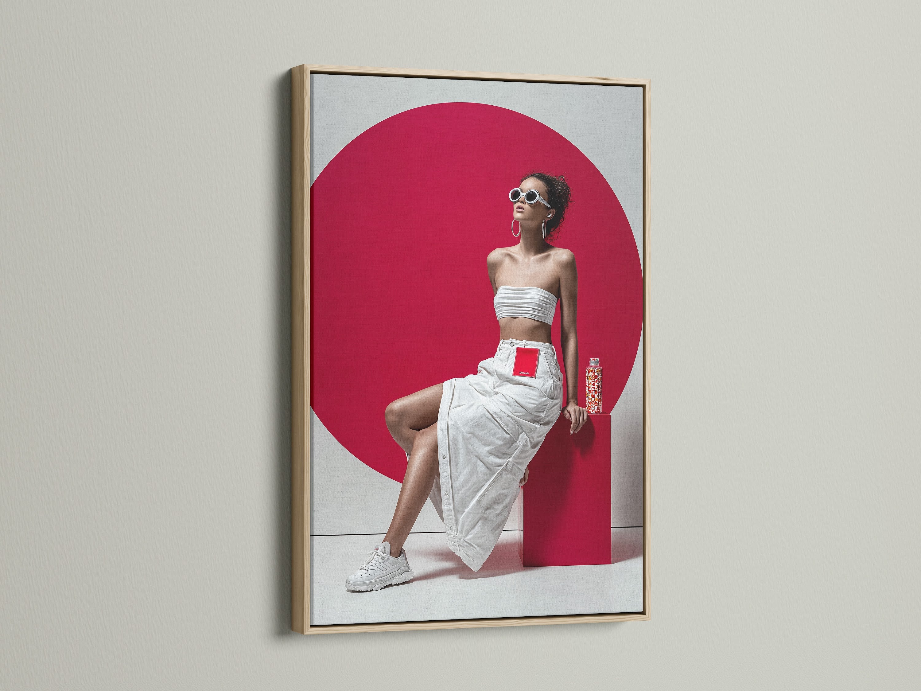 A modern pop art canvas print with an oak frame. The artwork features a woman in a white outfit and a bold red background. This portrait print is ideal for adding a contemporary touch to any living room or studio wall.