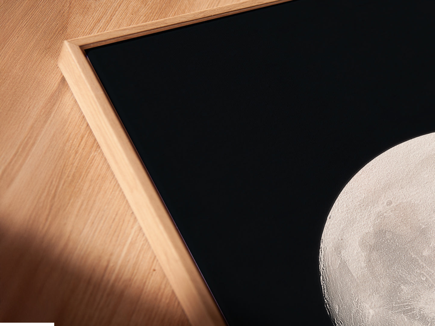 Angled close up of a Full Moon canvas print in a floating frame. This celestial art adds to astronomy decor. This is perfect moon phase art for any room. It is space themed art for a modern home. It makes a thoughtful astrology gift. Display it as a night sky print. It is beautiful full moon artwork and celestial print.