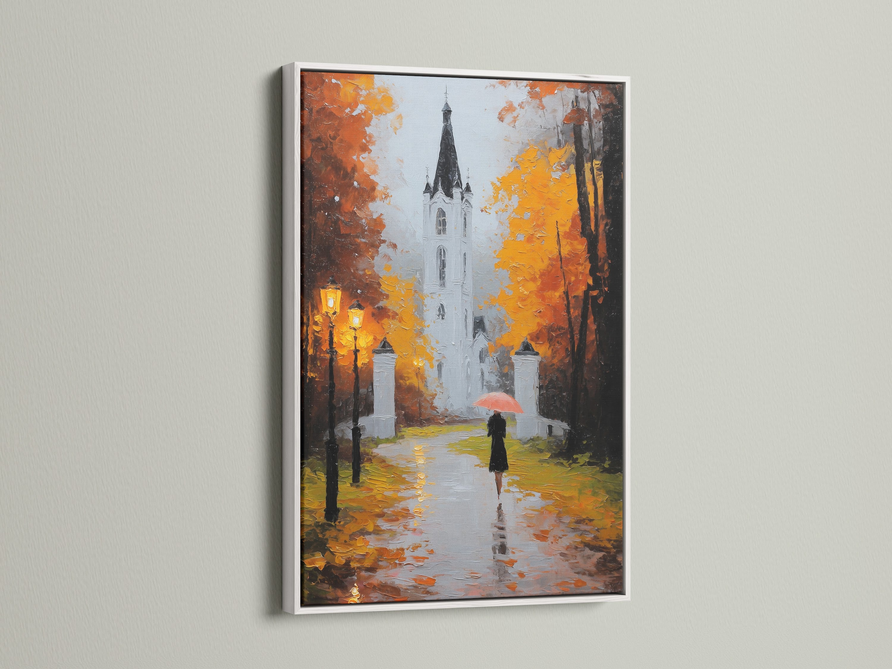 A white frame surrounds a beautiful piece of art displayed in a home. The art shows a building and a person with an umbrella. The white frame offers a clean look. Elevate your interior with framed art.
