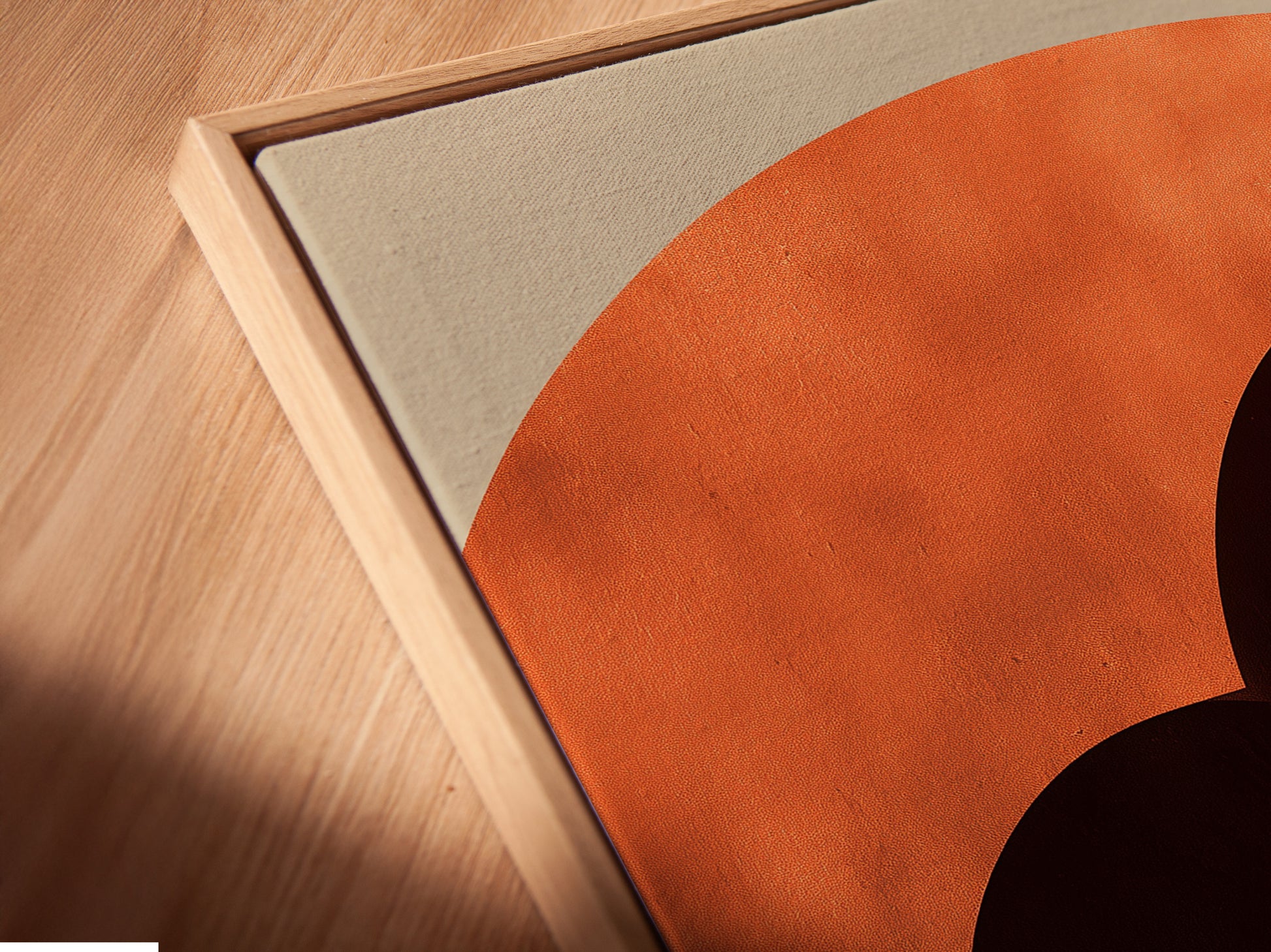 A close-up angled view reveals a canvas print in a floating frame. The artwork features terracotta arches. The floating frame adds depth and dimension. It separates the art from the wall for a gallery-like display.