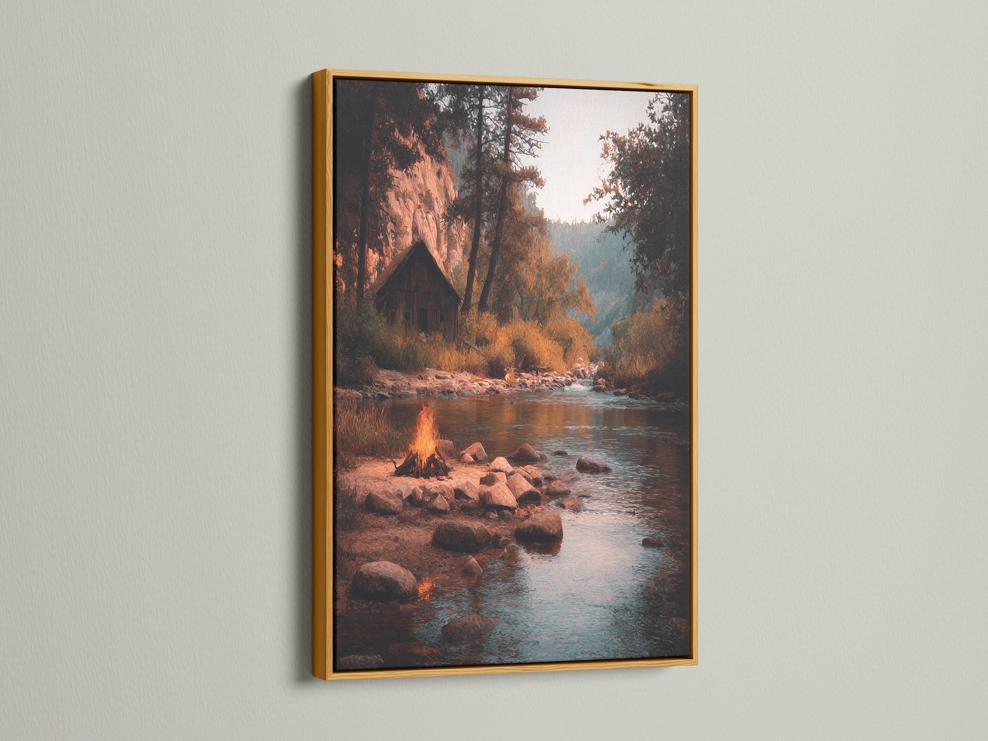 The artwork is presented in a gold frame. The artwork shows a river with campfire scene. The gold frame adds a touch of luxury. The art piece brings warmth and elegance to your home. This piece enhances any room's decor.