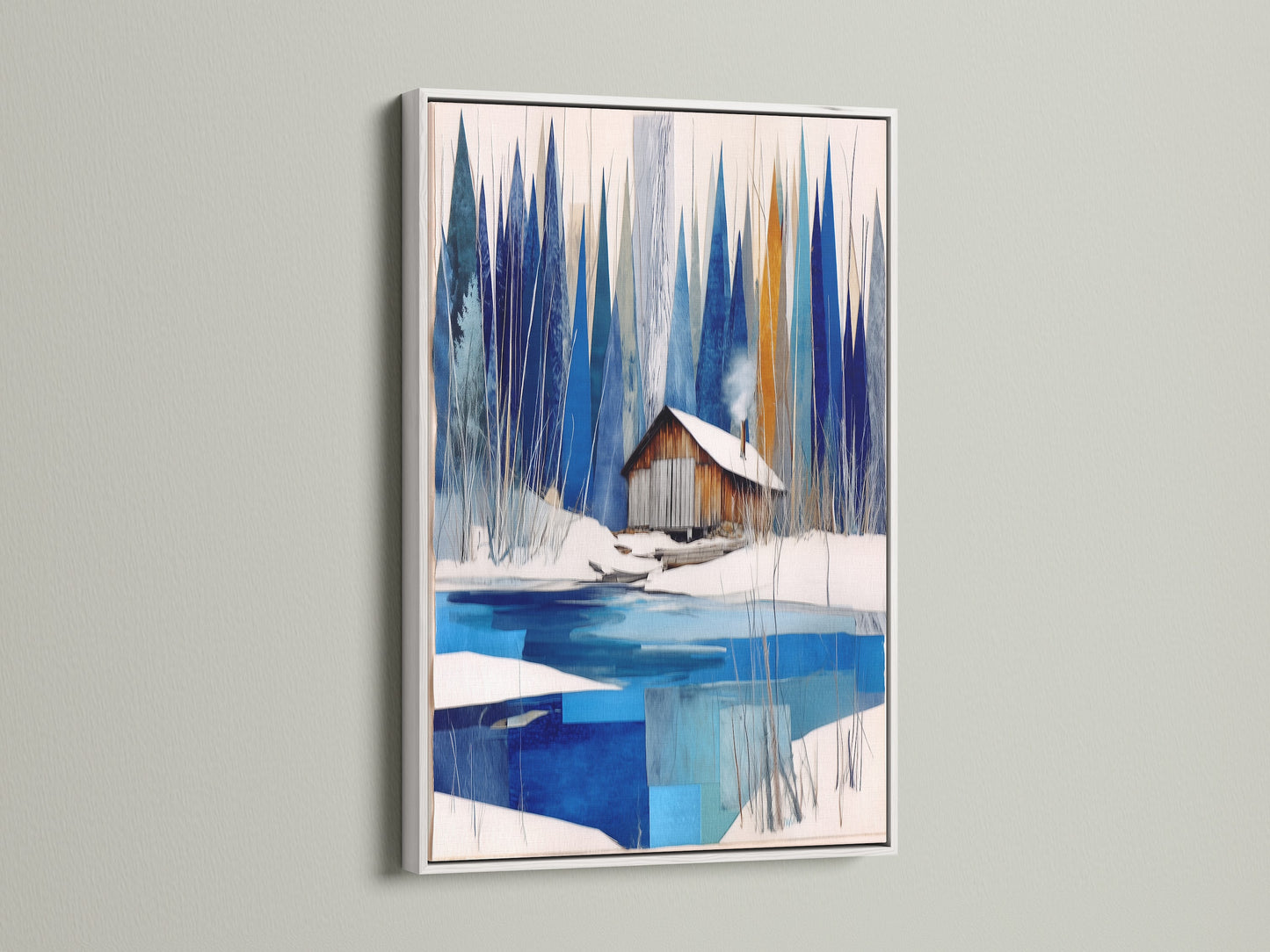 Winter Cabin Canvas Artwork with a white frame. Features snowy lake wall art for chalet decor. The white frame offers a clean crisp look to the blue and white abstract winter art. This modern wall art brightens any nature print. Ideal for lake house decor or winter cabin decor settings.