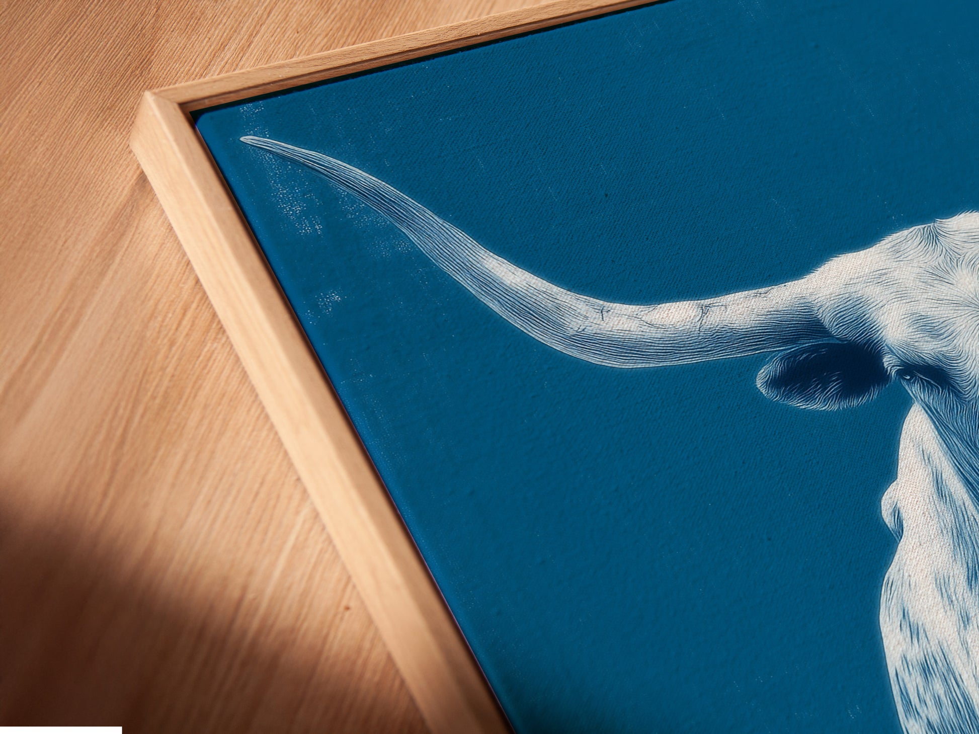 A close up of the canvas print is displayed in a floating frame. The longhorn bull artwork is a stunning piece of western ranch wall art. The floating frame adds a modern touch. Enhance your living room with this.